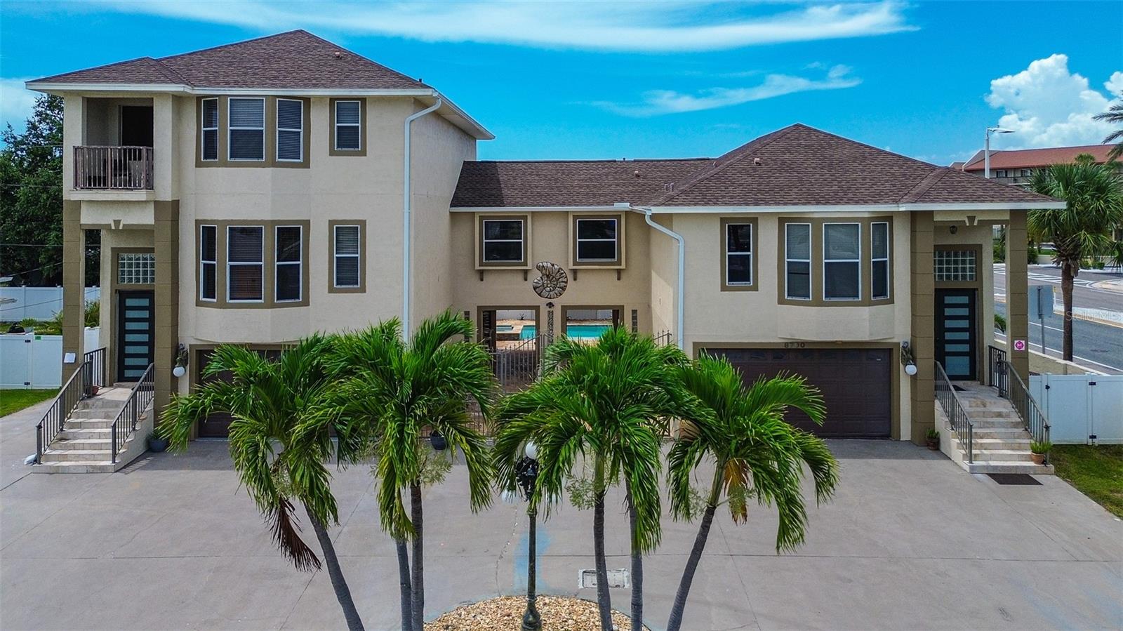 Step into a true slice of paradise with this stunning beachside duplex, which could also serve as a single family home located just moments from the iconic white sands of St Pete Beach. This exceptional property offers two distinct living spaces—each brimming with charm, comfort, and versatility.
The larger unit spans three thoughtfully designed levels and includes three spacious bedrooms, four bathrooms, and a versatile efficiency unit on the ground floor. The gourmet kitchen is a showpiece, featuring real wood cabinetry, gleaming granite countertops, a generously sized island, and stainless steel appliances. Artistic lighting and recessed fixtures create a warm and welcoming ambiance, while textured ceilings add character. The third level unveils two oversized bedrooms with private balconies overlooking the neighborhood and offering views of the Gulf. The master suite boasts a luxurious bathroom with a jacuzzi tub, stand-up shower, and a walk-in closet designed to impress.
Next door, the second unit offers its own flair with two bedrooms and two bathrooms, including a primary suite with rich plank bamboo flooring, a spacious closet, and a bathroom wrapped in elegant marble finishes. The kitchen is equally functional and stylish, with a central island offering plenty of storage, washer/dryer hookups, and a balcony that invites you to unwind while gazing out over the pool area.
Outside, the property transforms into a tranquil oasis. The sun-drenched courtyard features a shimmering swimming pool and a spill-over jacuzzi, all framed by gold travertine pavers laid in a classic French Pattern. Tropical landscaping sets the tone, while a Pebble Tech pool finish and custom blue glass waterline tile elevate the setting. A Generac generator stands ready for stormy days, and a separate shed offers easy storage for yard tools and beach cruisers.
Centrally located near top-tier dining, vibrant shopping, and, of course, Florida’s world-renowned beaches—this income-producing gem captures the essence of coastal living. Don’t let this rare opportunity drift away!
