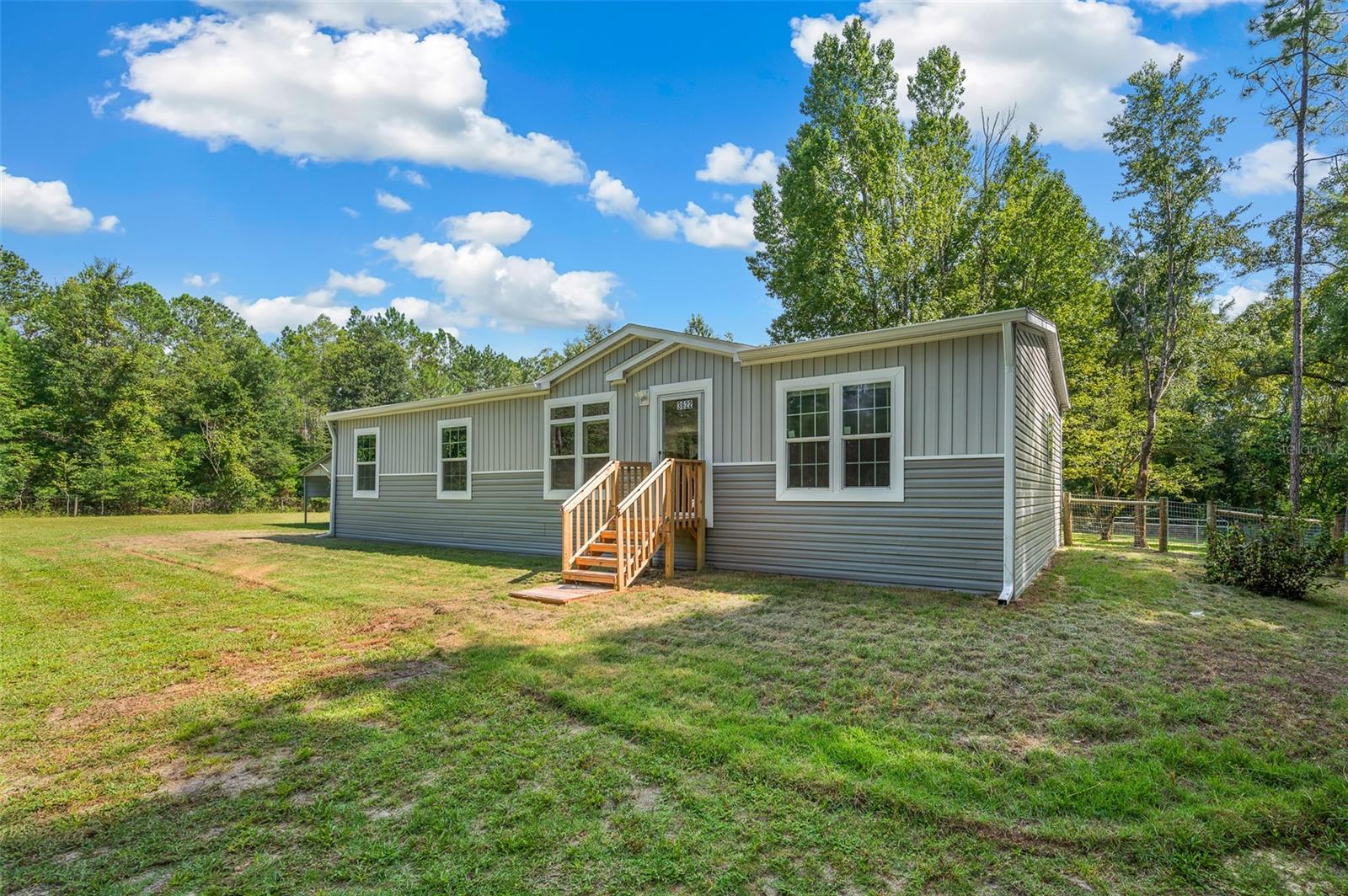 10 Beautiful acres........with 2 Mobile homes on site. 1st PROPERTY is a 1,456 sf 3 bedroom 2 bath built in 2025.. Features include open floor plan, vinyl plank flooring throughout, dining area, large kitchen with island, all appliances, along with washer/dryer & freezer. Master bath has walk in shower, 2 sink vanity w/separate make up area, walk in closet. Separate laundry room. Fenced in back yard.....open carport...... 2nd PROPERTY is a 1,248 double wide, 3/2 baths, built in 2012, has an open floor plan. 2 way split. Laundry room w/ washer & dryer. Screened porch on the back, Each property has it's own Septic tank, utilities and address. Both homes share one well. Out buildings: 1st building (Barn) for lawn equipment. 2nd building has open bay garage area.........This property offers a lot of living space across two separate residences, making it potentially suitable for multi-generational living, rental income, or even a home with a dedicated guest house. The acreage provides ample space and privacy. 1st PROPERTY is being sold AS-IS WITH ALL THE FURNISHINGS INCLUDING MOWER.
2nd PROPERTY is being sold AS IS.