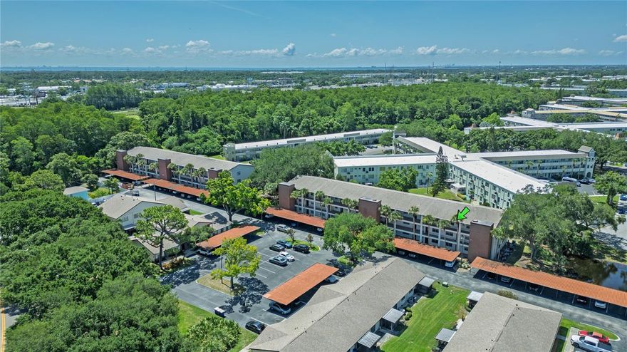 Located in the desirable Villas at Countryside community in Clearwater, this pet friendly condo puts you just steps from the heated community pool and clubhouse while keeping you close to some of the area’s best beaches, parks, shopping, and dining. Set in the heart of Countryside, the community offers an all ages setting with low HOA fees, assigned covered parking, guest parking, elevator access, shuffleboard courts, and proximity to Woodgate Park. Honeymoon Island State Park is approximately 10 miles away, with Clearwater Beach, Dunedin, Safety Harbor, Countryside Mall, US 19, Tampa International Airport, and St. Pete Clearwater Airport also within easy reach. Inside, the unit features a bright and functional layout with warm wood look flooring, neutral finishes, ceiling fans, and an easy flow between the living, dining, and kitchen areas. Large windows and sliding glass doors bring in natural light, helping the home feel open and welcoming. The kitchen offers plenty of cabinet storage, a double sink, pantry style storage, and a practical layout for everyday use, while inside laundry adds an important everyday convenience. The enclosed balcony is one of the standout features, adding approximately 130 bonus square feet of usable space that can be enjoyed as a sitting area, reading nook, morning coffee spot, or flexible bonus area. The bedroom offers direct access to the enclosed balcony, creating a nice extension of the living space, and the balcony also includes extra storage for added convenience. Whether you are looking for a full time residence, seasonal getaway, or low maintenance Clearwater retreat, this condo offers a great combination of location, amenities, value, and Florida lifestyle appeal.