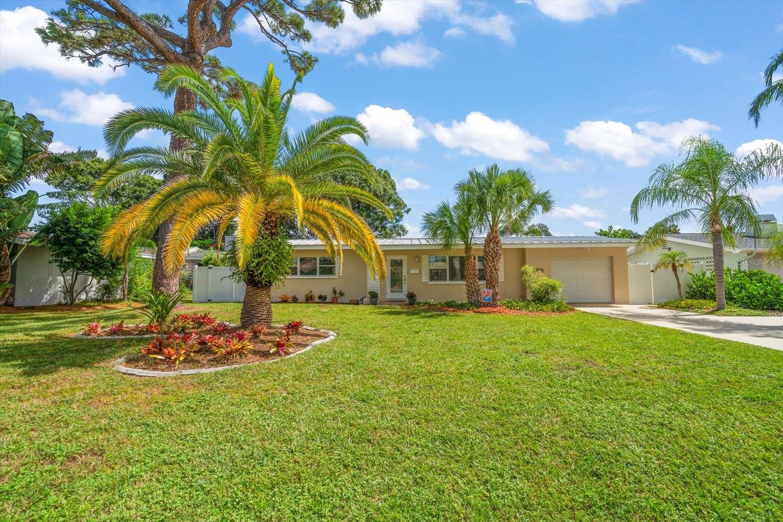 Welcome home! Tucked away on a quiet, seldom-traveled street in the sought-after Town of Belleair, this mid-century modern 2-bedroom, 2-bath home beautifully marries vintage character with modern comfort and convenience. Newly polished terrazzo floors shine under abundant natural light flowing through the spacious family and dining rooms creating an inviting ambiance. Sliders lead to a generous and fenced in private backyard and patio—ideal for gatherings, effortless entertaining, a future pool, or even an addition. A flexible bonus room offers the perfect spot for a home office, craft room or studio. Both bedrooms are light-filled with ample closets, and the baths showcase charming original tile. An indoor laundry with side yard access and a garage with extra storage add convenience to this move-in ready home. Perfectly positioned near boutique shopping, local dining, and world-class beaches, this Belleair treasure is a rare opportunity.