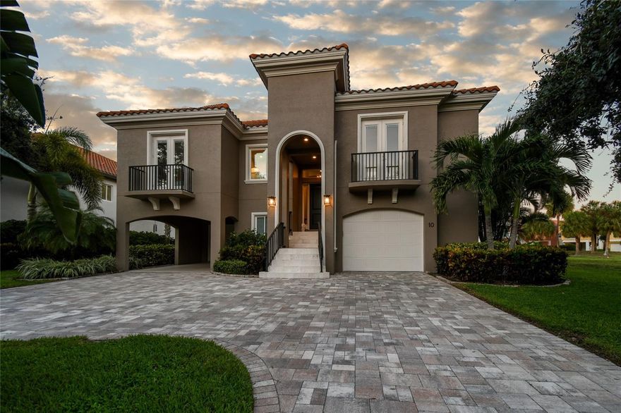 Discover a rare opportunity to own an exquisitely crafted home in the highly desirable Estates neighborhood of Marina Bay where contemporary Mediterranean charm with high-end features like a private elevator, infinity edge pool, a six-car garage and a gourmet kitchen with natural gas merge seamlessly with first-in-class resilient design, including elevated one-floor living, solid block construction throughout, hurricane impact windows and sliders, and a whole-house generator. Drive into the neighborhood beneath a graceful canopy of live oaks that frame the approach to this 3,239-square-foot, 4-bedroom, 3.5-bath residence, which offers a serene waterfront experience with a private marina mere steps away. It is rare to find a house that gets everything right: dimensions, flow, light, openness and a seamless blend of indoors and outdoors while maintaining private spaces, and this is just such a house.  As you enter 10 Bayfront, you'll find an open-concept floor plan that emphasizes spaciousness and natural light. It includes two living areas with sliders that bring the outdoors indoors, perfect for everyday living and entertaining. The heart of this home is the gourmet kitchen, featuring custom cabinetry, upgraded modern appliances, and a stunning tin ceiling for a unique ambiance. Quartz countertops and a nearly 10-foot island make it a culinary enthusiast's paradise, whether you're preparing a family dinner or hosting a grand soirée.The secluded owner's suite is a true embodiment of comfort and elegance, featuring tray ceilings, a large walk-in California custom closet, an ensuite bath with dual vanities, high-end fixtures, including a soaking tub, and a spacious tiled walk-in shower. Step outside to your personal paradise, where the marble tiled lanai extends your living space or relax on your poolside terrace, complete with cooling travertine pavers, next to your saltwater infinity edge pool. Host barbecues, sip cocktails by the water, or simply savor the cool breeze as you connect with the outdoors. 
 
All living accommodations are on one level and are served by a private elevator accessed from your 3,200 sq. ft. 6-car garage with epoxy flooring, making it suitable for cars, recreational equipment, a workshop, gym, or game room. Additionally, for your peace of mind, there's a whole-house 22kW GENERAC natural gas generator. Marina Bay is the only development in Pinellas County with fortified-quality all-block construction, impact windows and sliders and foam insulation for energy efficiency. The beauty of this home is enhanced by lush tropical landscaping and the numerous lakes dotted throughout Marina Bay. Residents delight in the watching the daily activities of osprey, herons, egrets, ibis, and ducks as well as the spectacle of pelicans diving for fish and dolphins and manatees play in Boca Ciega Bay beside the community’s deep-water marina. Additional amenities include two pools, two spas, a fitness center, a community clubhouse, and a fishing pier adjacent to the docks. Marina Bay is a pet-friendly community, just 10 minutes from downtown St. Pete, 25 minutes from Tampa Airport, and a short bike ride along the protected bike paths of Pinellas Trail to Pass-a-Grille and St. Pete Beach. Deep water boat slips available for purchase.