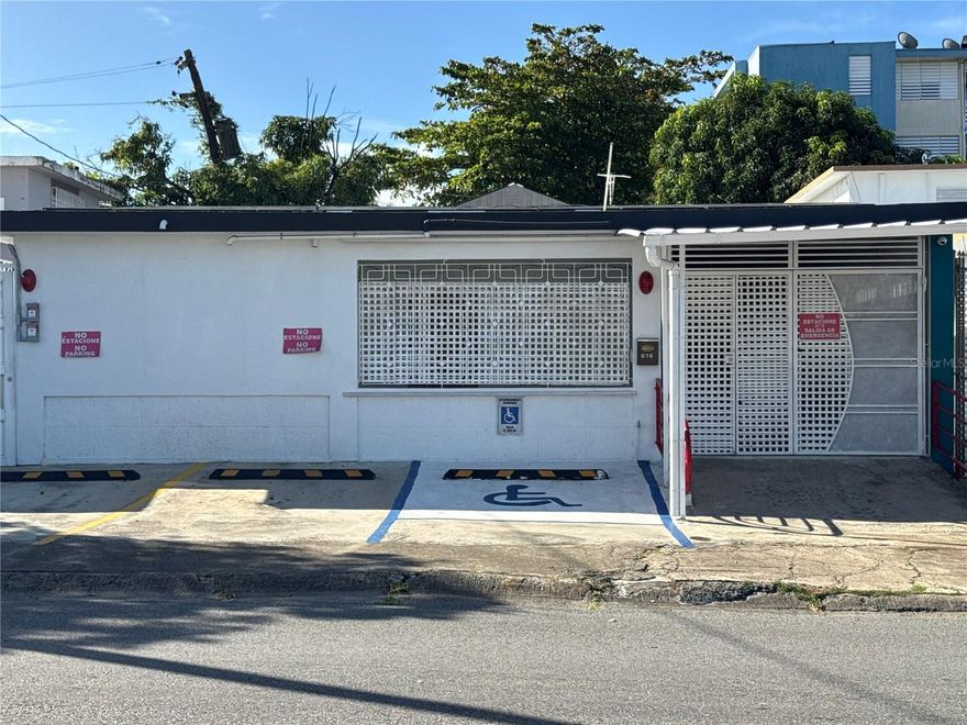 Located in Villa Prades, this versatile single-level property offers a unique opportunity for both residential living or commercial use. The property is currently configured to accommodate multiple uses and is equipped with significant energy efficiency upgrades and practical amenities.

The home features family and living areas, a functional kitchen, and access to a private patio, providing comfortable interior spaces that can easily adapt to different needs. The property includes five bedrooms, making it ideal for specialized residential use, assisted living concepts, short-term stays, or professional offices.

Energy efficiency is a standout feature, with 28 solar panels and three Tesla batteries, providing substantial energy independence and reliability. The home is also equipped with 5 inverter air conditioning units, an electric stove, range hood, refrigerator, and an 800-gallon water cistern with filtration system.

Additional features include a security system with cameras and monitors and parking for up to four vehicles. The property is habilitated with commercial parking spaces, including a designated handicapped spot, allowing for a seamless transition to office or service-based commercial use if desired.

This property presents an opportunity in San Juan for buyers seeking flexibility, sustainability, and functionality in a centrally located neighborhood.