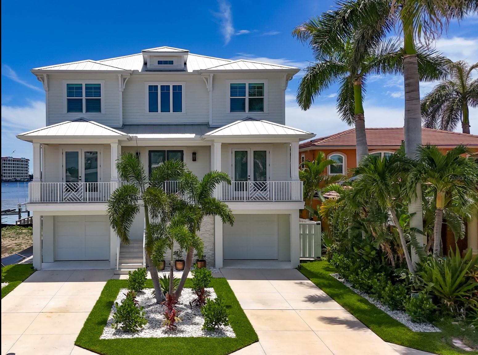 Sweeping 180 degree views of the Gulf from every room will leave you awestruck in this exquisite 2022 custom, waterfront estate. Part Hamptons, part Palm Beach and located in the small, quiet beach town of Redington Shores, this five bedroom, four bath, and four car garage has all of the modern amenities while still exuding warm, family charm. All living levels can be accessed by elevator from the garage or through the entry leading to the staircase with gleaming cable railings. Upon entry, the soaring, light filled gallery gives a feeling of grandeur as if coming to your favorite resort. White oak flooring throughout the home continues a modern, yet warm aesthetic. Two bedrooms and two full bathrooms flank the entry, both with East facing sunrise balconies overlooking the Intracoastal Waterway. The living room, kitchen and dining are overlooking the water where expansive views West to the beach are unmatched in any waterfront home. In the kitchen, Cafe appliances blend into the design with a stunning natural gas range, high end plumbing and a fridge and freezer large enough to accommodate the largest of families. The pantry with wine fridge, floor to ceiling storage and a washer/dryer tucked out of sight is the perfect addition to this entertaining space. Sliding doors that pocket out of view, open the living room to the patio, further immersing the space with a breezy water overlook. Hurricane shutters allow you to close off the balcony when you are away making it a perfect second home. Tear yourself away if you must and head upstairs to the gulfside primary retreat. If lazy mornings sipping coffee, perched over the water is your vacation plan then this is your new respite. The primary bathroom exudes elegance with marble and wood tile flooring, a soaking tub, separate toilet room and double vanity with plentiful storage. Double french doors to the walk in closet that you will find only in new construction, will have you saying C’est Magnifique at the options for storage and clothing. One bedroom with ensuite bathroom and a bedroom currently used as an office complete the third floor. Electric blinds, a central vacuum, audio speakers and a water softener are a few of the indoor conveniences. Outdoors on the ground level you have room for a pool and plenty of garage space for all the pool and boating equipment. Right off of the dock is a prime tubing, paddle boarding and waterskiing cove. Or drop a line right off the dock for some fishing fun. The 13,000 pound boat lift and dock will house your boat to get out to the Gulf via John’s Pass or Clearwater Pass for some of the finest fishing and blue water adventures in the area. The Redingtons are known for their residential appeal with very few commercial interests and a community feel. The beach is walking distance and has many public access points and parks with playgrounds to enjoy. New construction coupled with serene views and elegant and timeless design is yours. The seawall was buit in anticipation of a waterfront pool being added. The renderings show the owners preferred design for a pool but you can modify and build to your taste.