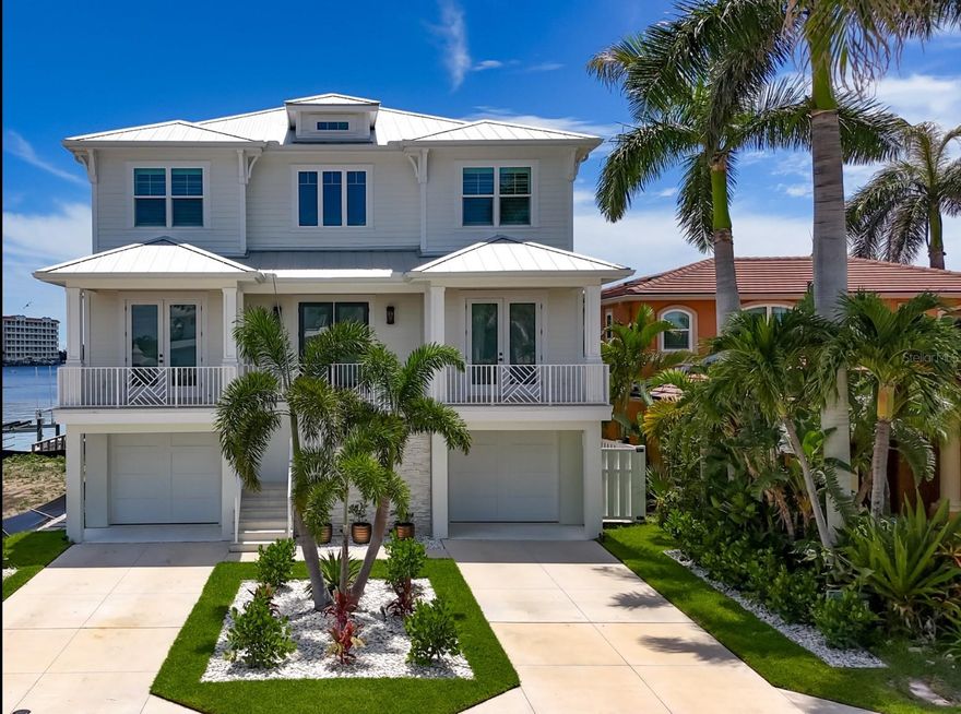 Sweeping 180 degree views of the Gulf from every room will leave you awestruck in this exquisite 2022 custom, waterfront estate. Part Hamptons, part Palm Beach and located in the small, quiet beach town of Redington Shores, this five bedroom, four bath, and four car garage has all of the modern amenities while still exuding warm, family charm. All living levels can be accessed by elevator from the garage or through the entry leading to the staircase with gleaming cable railings. Upon entry,  the soaring, light filled gallery gives a feeling of grandeur as if coming to your favorite resort. White oak flooring throughout the home continues a modern, yet warm aesthetic. Two bedrooms and two full bathrooms flank the entry, both with East facing sunrise balconies overlooking the Intracoastal Waterway. The living room, kitchen and dining are overlooking the water where expansive views West to the beach are unmatched in any waterfront home. In the kitchen, Cafe appliances blend into the design with a stunning natural gas range, high end plumbing and a fridge and freezer large enough to accommodate the largest of families. The pantry with wine fridge, floor to ceiling storage and a washer/dryer tucked out of sight is the perfect addition to this entertaining space. Sliding doors that pocket out of view, open the living room to the patio, further immersing the space with a breezy water overlook. Hurricane shutters allow you to close off the balcony when you are away making it a perfect second home. Tear yourself away if you must and head upstairs to the gulfside primary retreat. If lazy mornings sipping coffee, perched over the water is your vacation plan then this is your new respite. The primary bathroom exudes elegance with marble and wood tile flooring, a soaking tub, separate toilet room and double vanity with plentiful storage. Double french doors to the walk in closet that you will find only in new construction, will have you saying C’est Magnifique at the options for storage and clothing. One bedroom with ensuite bathroom and a bedroom currently used as an office complete the third floor. Electric blinds, a central vacuum, audio speakers and a water softener are a few of the indoor conveniences. Outdoors on the ground level you have room for a pool and plenty of garage space for all the pool and boating equipment. Right off of the dock is a prime tubing, paddle boarding and waterskiing cove. Or drop a line right off the dock for some fishing fun. The 13,000 pound boat lift and dock will house your boat to get out to the Gulf via John’s Pass or Clearwater Pass for some of the finest fishing and blue water adventures in the area. The Redingtons are known for their residential appeal with very few commercial interests and a community feel. The beach is walking distance and has many public access points and parks with playgrounds to enjoy. New construction coupled with serene views and elegant and timeless design is yours.  The seawall was buit in anticipation of a waterfront pool being added.  The renderings show the owners preferred design for a pool but you can modify and build to your taste.