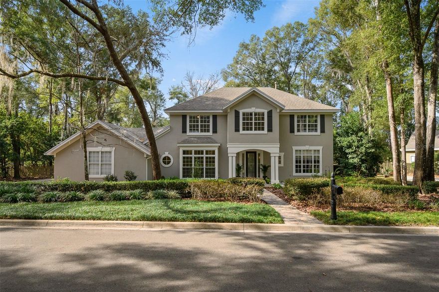 You'll love coming home to this completely renovated two-story luxury home situated on a premium lot in Haile Plantation. Exceptional curb appeal and a brick paver pathway leads to this stately home with a gorgeous leaded-glass front door. Inside, the elegant formal dining room sits to the left, featuring classic wainscoting and a stunning chandelier—perfect for entertaining. Beyond the dining room, the expansive family room impresses with cathedral ceilings, a dramatic lighted stone entertainment wall, and a gorgeous oversized chandelier that anchors the space. The chef’s kitchen is truly the heart of the home, thoughtfully designed with stainless steel appliances including a Wolf six-burner gas cooktop, a wall oven and microwave, granite countertops, custom wood cabinetry, a wine refrigerator, and a wood vent hood. A large island with a prep sink provides additional workspace.  The kitchen overlooks the breakfast nook and the sun-filled Florida room, which features a wood-burning fireplace and a coffered ceiling, all overlooking the newly landscaped, expansive backyard. Located between the dining room and kitchen is an incredible butler's pantry with a built-in oven, granite countertop, glass door cabinetry and a large walk-in pantry with custom shelving. Just off the kitchen is a well appointed full bath ideal for pool or outdoor access.The large laundry/mud room is complete with a second refrigerator, a sink, lots of cabinets and a window. The primary suite is conveniently located on the main level and offers a large walk-in closet and a beautifully renovated, spa-like en suite bath with dual vanities, a free standing soaking tub, and an exceptional walk-in shower with floor to ceiling tile and multiple shower heads. Also on the main floor is a spacious guest bedroom with a Murphy bed, a fully renovated hall bathroom with a walk-in shower. Upstairs, you’ll find a generous flex space, two additional bedrooms, and a full bathroom with double sinks and a tub/shower combination. A large storage/bonus room adds versatility, and one of the  upstairs bedrooms is plumbed for an additional bathroom. Step outside to a private, low-maintenance, fenced backyard featuring a hot tub, a charming gazebo with swings, and a fire pit—perfect for relaxing or entertaining. The Haile Plantation community offers miles of walking trails, parks, playgrounds, basketball, a Village Center with shops and restaurants and the Hawkstone Country Club. The Hawkstone Country Club (membership required) offers dining, golf, tennis, pickleball, a gym and two pools.