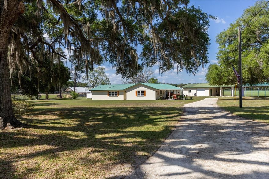 Welcome to a truly exceptional opportunity to own a breathtaking 20-acre ranch in highly sought-after Gilchrist County—where refined comfort, thoughtful design, and peaceful country living come together in perfect harmony. Privately tucked just off a paved road behind a gated entrance, this remarkable property unfolds with sweeping pasture views, majestic mature oaks, and a gentle, year-round breeze that captures the very essence of North Florida living. The fully renovated solid block home has been meticulously maintained and beautifully upgraded, blending rustic ranch charm with elevated, high-end finishes. Designed for both everyday living and effortless entertaining, the spacious split floor plan offers four bedrooms and two bathrooms, complemented by two inviting living areas—one centered around a cozy fireplace, perfect for relaxing evenings at home. Natural light pours in through new windows, highlighting the warmth and character throughout.

At the heart of the home, the stunning kitchen is both functional and eye-catching, featuring granite countertops, new appliances, and custom high-end cabinetry with pull-out drawers and unique, one-of-a-kind fixtures. A picturesque window above the sink frames serene views of the property, bringing the beauty of the outdoors right into your daily routine. The primary suite is a true retreat, complete with a dream walk-in closet fully customized with built-ins, shelving, and drawers for optimal organization. Step outside and experience what truly sets this property apart. Designed with the equestrian enthusiast or working farmer in mind, the pristine 60x48 horse barn features four oversized 12x28 stalls with flexibility to reconfigure, along with a well-designed wash station for ease and efficiency. The land is fully fenced with durable RAM fencing and thoughtfully divided into four paddocks, making it perfectly suited for horses or livestock.
Adding even more versatility, the enclosed concrete shop with an attached two-car carport provides a highly functional space—ideal for a workshop, storage, hobbies, or even a home-based business. Additional improvements include multiple outbuildings for gardening, a tack room, and equipment storage. A charming chicken coop—complete with resident chickens—adds to the authentic farmstead lifestyle, while mature pear and pecan trees provide both beauty and bounty. This is more than just a property—it’s a turnkey ranch lifestyle offering privacy, functionality, and endless possibilities, all in a location that keeps you conveniently connected while feeling worlds away.