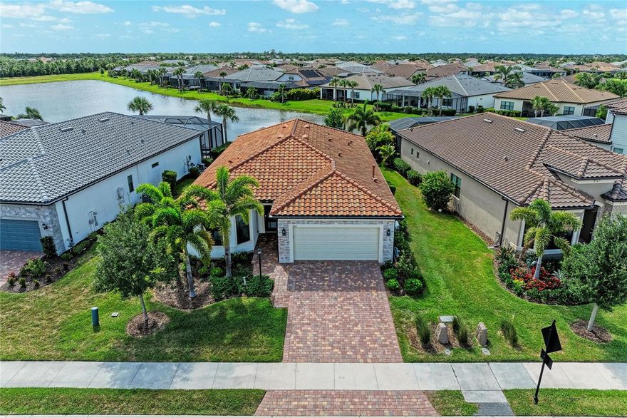 Welcome to this beautifully upgraded Mystique model with extended lanai in the highly desirable 55 Plus community of Del Webb Lakewood Ranch. Perfectly positioned with a peaceful water view and tucked away from the busier roads, this home also enjoys close proximity to the secondary community pool and amenities for added convenience. The extended covered lanai is one of the standout features of the home, offering tranquil water views, remote-controlled hurricane-rated screens, and a solid privacy wall that creates the potential for future enclosure if desired. There is also room for a future pool. An additional astro turf provides versatility as a putting green, pet area, or possible future hot tub space. 

This thoughtfully designed 3-bedroom plus study home offers 2,084 sq ft of open living space with porcelain tile throughout, quartz counters throughout, custom trim work, custom lighting, dimmer switches, ample ceiling fans throughout, 8 ft doors, and elegant custom paint finishes. The spacious study with solid double doors provides flexibility for a home office, den, or guest overflow space. 

The kitchen features an oversized quartz island, abundant cabinetry, induction cooktop with custom overhead venting system, wall oven, separate microwave, walk-in pantry, and an open flow into the dining and living areas-ideal for entertaining. The natural gas line is currently capped as a future alternative if preferred. All major appliances are included with the home.


The primary suite offers a spacious and thoughtfully designed retreat with a large walk-in shower, dual vanities, quartz counters, tile extended to the ceiling for an elegant finish, grab rails for added convenience, a linen closet, and a large customized walk-in closet. Pocket doors in two locations enhance the overall flow and functionality of the suite, including the private water closet area.

The secondary bedroom features upgraded impact-rated bay windows that enhance both natural light and storm protection. The remaining windows include professionally installed 3M protective film for additional comfort and peace of mind. The guest bath also includes grab rails and tile extended to the ceiling, creating a refined and cohesive design throughout the home.
Additional upgrades include a whole-house generator, hurricane shutters, epoxy garage floor, high-end electric washer and dryer with pedestals, and an exceptionally functional laundry room complete with a sink with cabinet, second refrigerator, custom wall closet system, upper storage, clothes drying rods, and a large storage area. The relocation of the air handler to the garage ceiling creates additional usable laundry and storage space while contributing to quieter interior living areas. 
Del Webb Lakewood Ranch offers resort-style amenities including pools, fitness center, clubhouse, "Cheers" restaurant, pickleball, tennis, social activities galore, and gated entry-all within one of the nation's premier master-planned communities in the country, Lakewood Ranch.