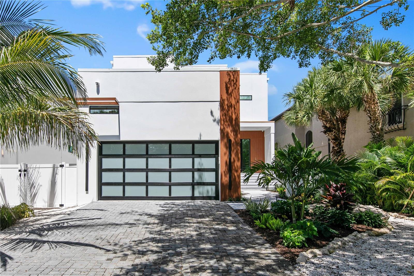 Sophisticated and sleek, this dazzling masterpiece is located along the grand canal in the heart of Siesta Key. A modern exterior will impress neighbors and onlookers with sharp lines and a refined combination of materials that blend style and durability for island living. A courtyard provides a private entrance for you to welcome guests into the two-story foyer illuminated by an intriguing chandelier. An adjacent study featuring custom metal French doors is the perfect spot to accomplish business endeavors or organize your complex family calendar. The kitchen is truly the heart of the home with attractive cabinetry, handsome hardware, paneled appliances and pristine quartz countertops that shimmer under fashionable light fixtures. Display gorgeous glassware and invent an impressive aperitif from your convenient bar area with glass-front cabinetry, floating shelves with accent lighting and a bar sink. The captivating details continue to astonish in the great room featuring soaring ceilings, innovative design details and a chandelier that radiates elegance. The best of the Florida lifestyle can be yours with seamless indoor/outdoor integration through disappearing sliders leading to your outdoor entertainment space. Grill and dine in comfort on your covered patio while enjoying the shimmering pool and generous, surrounding sun deck. Rinse the day’s adventures away in your outdoor shower before heading inside to relax and recharge. This home offers two principal suites with equally impressive en-suite bathrooms – one on the first level with private access to the patio and the second is on the upper level. The second floor boasts a flexible loft area and two additional bedrooms each with a private bath. Ascend the circular staircase to your rooftop terrace, where you can sunbathe or star gaze from sunrise to sunset. A glass railing system around the multiple patios grants an unobstructed view of the grand canal, a 10-mile long network of shallow canals that are the playground for wading birds, manatees and dolphins. Anticipate gliding in your watercraft to Roberts Bay as this property includes a boat dock and lift, currently in permitting. Take a short walk and lounge on the world-renowned sands of Crescent beach, shop or dine at Siesta Key village, or venture a bit further to find culture, adventure and recreation along Florida’s many gulf coast cities and barrier islands. State of the art design and excellence in construction, TDI Coastal Homes constructs luxury spaces that exceed expectations and completes your lifestyle with a home that feels extravagant yet effortless.