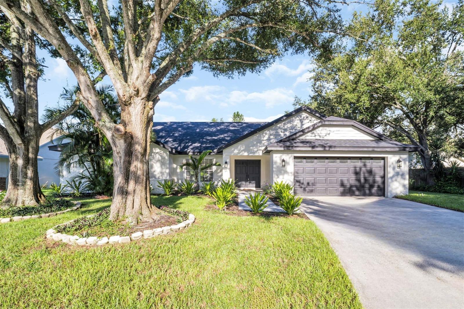 Gorgeously renovated and perfectly situated between Palm Harbor and Dunedin, this stunning 4-bedroom, 3-bathroom home in the sought-after Waterford Crossing community offers luxury living at its finest. Step through the elegant double-door entry and be welcomed by soaring vaulted ceilings, a freshly painted interior, all updated fans, fixtures, and hardware, and beautiful sea salt luxury vinyl flooring that flows seamlessly throughout the thoughtfully designed open and split-bedroom floor plan. The heart of the home is an absolutely jaw-dropping kitchen renovation, featuring quartz countertops, custom backsplash, an oversized island plus a breakfast bar, all brand new LG appliances, and modern recessed lighting—opening beautifully to the spacious family room with a wood-burning fireplace and custom built-in desk. The primary suite is a true oasis with large sliders leading out to the screened lanai and peaceful conservation views of the over half-acre lot and showcases a spacious walk-in closet plus a separate built-in, a luxurious en-suite bath complete with dual vanities, a dedicated make-up station, a brand-new deep soaker tub, and a stunning walk-in glass shower with custom tile and rain showerhead. The freshly screened lanai features two sets of large sliders and two double doors from the main living areas, creating an ideal indoor-outdoor flow for relaxing or entertaining. This home is truly move-in ready with a freshly painted exterior, sleek new exterior lighting, and major upgrades including a brand NEW ROOF (2024), HVAC (2024), electrical panel (2024), and hot water heater. Located in a NON-FLOOD ZONE, but just a short walk or jog to the Dunedin Causeway, Honeymoon Island, Caladesi Island, and beautiful Gulf Beaches. Waterford Crossing offers a beautiful community park, scenic trails and nearby with easy access to the Pinellas Trail. With a recently passed 4-point inspection and essentially EVERYTHING NEW, there are no insurance worries. Zoned for top-rated schools and close to vibrant dining, shopping, and entertainment, this home offers better-than-new construction in an unbeatable location—an exceptional opportunity you don’t want to miss!