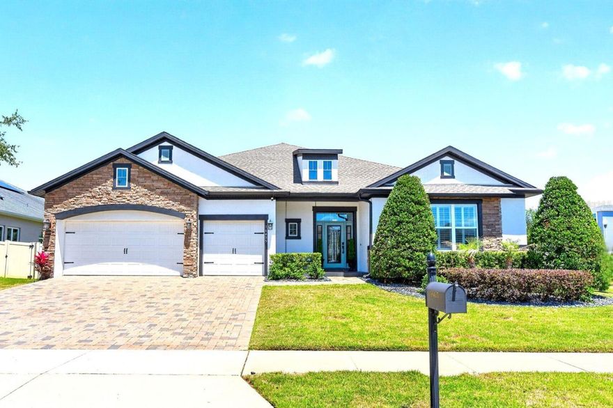 OWNED SOLAR, a CUSTOM BACKYARD OASIS, and a long list of thoughtful UPGRADES come together in this beautifully enhanced home in the highly sought-after Johns Lake Landing community of Clermont! From the moment you arrive, the BRICK PAVER DRIVEWAY and BRICK FACADE set the tone and it is clear this property was designed for elevated living with comfort, style, and functionality in mind. Step inside to find WOOD LOOK TILE flooring throughout, high ceilings, crown molding, 8-FOOT DOORS, and a light, bright OPEN CONCEPT layout that still offers defined living and dining spaces. The living room is anchored by an ELECTRIC FIREPLACE and TRIPLE SLIDING GLASS DOORS that open seamlessly to the COVERED LANAI, creating the ultimate INDOOR/OUTDOOR LIFESTYLE Florida is known for. The kitchen is a true showpiece, featuring a fresh modern color palette, upgraded appliances, sleek hardware and fixtures, a subway tile backsplash, a large ISLAND with bar seating, and a window that fills the space with natural light. Just beyond, a massive 17x12 CUSTOM BUTLER'S PANTRY/MORNING ROOM delivers incredible storage and functionality and is perfect for keeping everything organized and within reach.  The SPLIT BEDROOM floor plan offers privacy, with a huge PRIMARY SUITE that feels like a retreat, complete with a SITTING AREA, abundant natural light, and a beautifully REMODELED EN-SUITE BATH. Additional bathrooms have also been thoughtfully updated, and the home features CUSTOM BUILT-IN SHELVING, DESKS, and a FLEX SPACE along with CLOSET ORGANIZERS, PLANTATION SHUTTERS throughout, and ample storage at every turn. Out back is where this home truly shines. Situated on a spacious .25 ACRE CORNER LOT, the private backyard oasis is built for both entertaining and unwinding. A CUSTOM LOUNGE WATER FEATURE seats 13 with LED lighting and a cascading waterfall and serves as a one-of-a-kind centerpiece. The POOL with SUN SHELF invites all-day relaxation and the stunning LIMESTONE TILE pool deck and patio create a resort-quality finish underfoot. The fully equipped OUTDOOR KITCHEN features GRANITE COUNTERTOPS, a top-of-the-line TRAEGER GRILL, convection, outdoor fridge and pull-outs, and is finished beautifully for both form and function. BUILT-IN FIRE PIT SEATING, Wi-Fi OUTDOOR SPEAKERS, and a CUSTOM PUTT PUTT AREA round out an outdoor experience you simply will not find anywhere else. LANDSCAPE LIGHTING illuminates the trees, walkways, and home exterior for stunning evening ambiance, and the fully fenced yard expanded to the property line maximizes every inch of usable space. The home also features OWNED SOLAR PANELS with no payment, an EV CHARGER in the garage, and overhead garage storage racks providing all the practical upgrades that make daily life easier and more efficient. Located in a vibrant LAKE COMMUNITY centered around SKIABLE JOHNS LAKE, residents enjoy well-maintained common areas, a community pool, park and playground, and easy access to the Johns Lake boat ramp just minutes away. Zoned for "A" RATED Grassy Lake Elementary and conveniently located near SR 50 and the Florida Turnpike, you are just a short drive to shopping, dining, entertainment, and the entire Clermont Chain of Lakes. This is more than a home. It is a lifestyle. Thoughtfully designed, move-in ready, and filled with upgrades at every turn, this Clermont pool home delivers comfortable luxury with no detail missed!