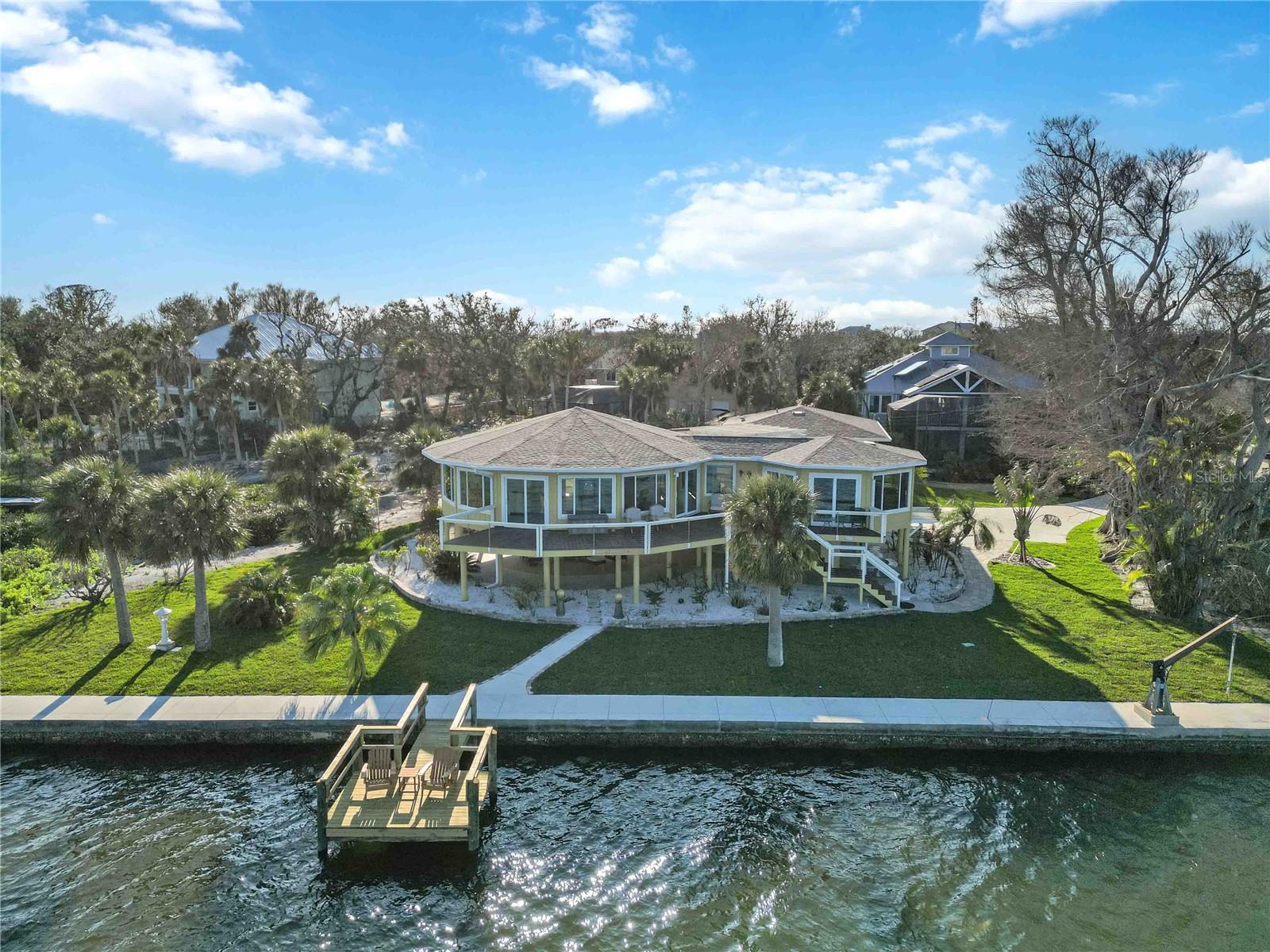 UNSURPASSED EXPANSIVE VIEWS of LEMON BAY are waiting for you here! With so much of old Florida disappearing, this MOVE IN READY home is one of a kind. Anyone who yearns for a TURNKEY PRIVATE getaway, with DEEDED BEACH ACCESS situated in a quiet community, will immediately recognize this rare opportunity. Prepare to relax! As you drive down to the end of a short gravel road, you will feel the tranquility this home offers with its charming, even whimsical design. The ELEVATED WATERFRONT construction gives you the kind of vantage points that make it feel like your own private resort. Explore the new TROPICAL LANDSCAPING maintained by a full irrigation system as well as the EXPANSIVE COVERED OUTDOOR LIVING space that is perfect for adding a hot tub, swinging chairs, ping pong table, and more. Come on inside. Choose any room because every room has a view of Lemon Bay and access to a deck. The PANORAMIC VIEWS of the bay are nothing short of BREATHTAKING! Banyan trees, resident bald eagles keeping watch, dolphins, manatees, sting rays, splashing fish, singing birds and more are all a part of your daily visual extravaganza! As you relax, you will also appreciate the care the owner has put into this home. Storm fortification in 2014 included an $80,000 PANORAMIC wall of PGT HURRICANE WINDOWS and SLIDING GLASS DOORS leading to the CABLED DECKING. In 2024, newly added amenities include GORGEOUS MARBLE FLOORING, a complete DUAL ZONE AIR CONDITIONING SYSTEM, large capacity WATER HEATER, and GARAGE DOORS, WINDOWS, CUSTOM BUILT-IN SHELVING, and COMPLETELY REFURBISHED HALF BATH. The unique floor plan offers three bedroom suites, each situated in their own wing with their own full bath affording privacy for a multigenerational vacation, or for a couple that likes to entertain, or even for the occasional special rental opportunity. The largest suite is conveniently positioned where it could have a separate private entrance. All suites converge in the great room, the heart of the property, where the expansive views are enjoyed by all as memories are made to last a lifetime. Speaking of memories, a favorite of the current owner is to rent kayaks and paddle home to the private DOCK and SEAWALL while watching the frollicking dolphins at play nearby. When you want to venture out, there is an amazing community to complete your experience. What can you say about a small town that lends life jackets on the honor system at the public boat launch? MANASOTA BEACH PARK and THE SCRUB PRESERVE are both open. Join the VENICE YACHT CLUB or the MANASOTA FOSSIL CLUB. The HERMITAGE celebrates its reopening on Jan 30th, and residents look forward to the HISTORIC MANASOTA BEACH CLUB opening soon. Situated on the southern part of the key you can easily take advantage of recently reopened RESTAURANTS and SHOPS to ease into your casual island living routine. Don’t miss your chance to explore this amazing property located in one of the TOP 10 PLACES TO RETIRE according to Southern Living, and make it your new home in old Florida!