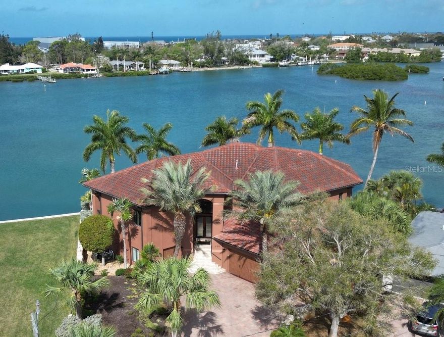 **Welcome to 420 Palmetto Crescent – A Luxurious Waterfront Oasis** Step into a realm of unparalleled elegance and breathtaking waterfront views at this custom-built masterpiece by Beechwood Builders. Nestled in the serene Nokomis, Florida, this stunning residence boasts 145 feet of private bay frontage, offering direct access to the Gulf of America just minutes away—perfect for boating enthusiasts. This exquisite 3-bedroom, 2.5-bath home is designed for both relaxation and entertainment. The spacious garage accommodates up to 7 cars and includes a workshop area. Dive into the luxurious saltwater pool or unwind in the spa, by an inviting outdoor kitchen, featuring a new gas grill, ideal for alfresco dining. The beautifully landscaped property features a meticulously laid paver brick driveway, as well as, pavers surrounding the pool and covered lanai. Low-maintenance artificial turf eliminates the need for mowing. At the heart of the home lies a chef’s kitchen, complete with top-of-the-line Jenn- Air appliances. Elegant cherry wood cabinets and doors throughout add a warm touch, and designer pendant lights create an inviting atmosphere over the expansive island. The grandeur continues in the great room, which features a double bump-up ceiling soaring to 14 feet, adorned with sophisticated crown molding and a wet bar complete with a beverage cooler.  Enjoy seamless transitions from the living and dining areas to the balcony, where you can revel in serene views overlooking the pool, spa, and picturesque Lyons Bay. Centrally located, this luxurious residence is just a stone's throw from shopping, gourmet restaurants, stunning beaches, and the charming Venice Island. Experience the lifestyle you have always dreamed of—schedule your private showing today and make 420 Palmetto Crescent your luxurious waterfront sanctuary.