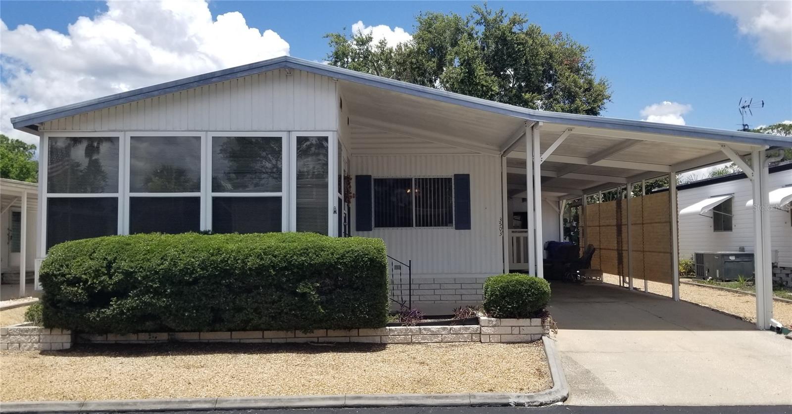 This Lovely Doublewide Mobile Home has been well maintained and move in ready. Tiki Village is a 55+ friendly community tucked in off US 19 where you own your land with a low HOA Fee of just $520.00 a year. The park is in a non flood zone. Nice open floor plan, high ceilings with enclosed front porch. Large and spacious master bedroom with xtra large walk in closet and natural lighting. Both bathrooms have tons of storage. Utility shed with washer and dryer and covered carport with access to back yard. Home is nicely furnished and waiting for new home owner! Just minutes away from shopping, restaurants, parks and the famous Tarpon Springs Sponge Docks. Looking for affordable Florida living? Buyers will not be disappointed.
