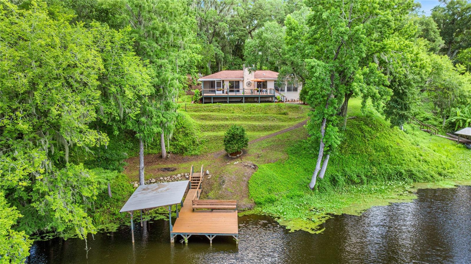 WATERFRONT PARADISE! BOAT DOCK! BOAT HOUSE!
Welcome to your dream riverfront escape in the heart of Dunnellon! This beautifully 3 bedroom, 2-bathroom home with a 2-car garage sits on an impressive 247 feet of pristine waterfront on the Withlacoochee River, just minutes—or a short boat ride—from the crystal-clear Rainbow River. Step inside and be greeted by imported Italian tile floors, a cozy wood-burning fireplace, and panoramic river views through expansive glass windows that span the rear of the home—designed to bring the natural beauty of the outdoors inside.
Enjoy direct access to the San Jose Blvd Trailhead, offering paved walking and biking trails perfect for outdoor enthusiasts not to mention the abundant deer and other wildlife on this protected Greenway. Step out to your newer boat house, dock, and oversized back deck—ideal for relaxing, entertaining, or launching your next river adventure.
The property is a true gardener’s delight, with a beautifully landscaped yard featuring orange, lemon, grapefruit, and avocado trees, along with a cascading grapevine that adds to the lush, tropical ambiance. Freshly painted outside, this home also features a paved driveway and a new storage building conveniently located beside the garage. Enjoy the peaceful, small-town charm Dunnellon is known for, with nearby top-rated schools, charming shops in the Historic District, and the World Equestrian Center just 20 minutes away. Plus, you're just a short drive from the Gulf of Mexico. Homes of this quality, character, and location rarely come along—don’t miss your opportunity to own a piece of Florida’s waterfront paradise! Seller will consider Owner Financing.