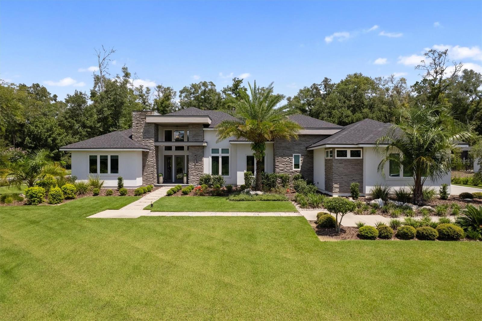 Former AR Model Home by Arthur Rutenberg Homes featured in the 2022 Parade of Homes offers Florida living at it's finest! Situated on a 1-acre corner homesite, this estate home in Oakmont features 4 bedrooms, 4.5 bathrooms, den/office, bonus room, 3-car garage, and a resort style outdoor living space. Clean lines, contemporary materials and extensive use of glass set the stage for this wide open, welcoming home. High ceilings draw the eye up while pocketing walls of glass extend the space horizontally, leading from the main living area to the covered cabana and lanai. A centrally-located kitchen offers stunning views to the pool and manicured backyard and boasts a floating ceiling with back lighting, commercial grade appliances, quartz countertops and a large island with seating creates an ideal home for entertaining. A walk in pantry offers a 2nd refrigerator, built in shelving and a built-in countertop/cabinet "appliance" station.
A strategically located den in the front of the home offers large windows with impressive views. This corner lot overlooks a large community common area to the front allowing for maximum privacy. Guests will love their VIP suite with kitchenette, seating area, dinette space, walk in closet and en suite bathroom. The owner’s suite offers spacious luxury away from it all featuring a beautifully appointed bathroom, walk in closet with double islands that directly connects to an oversized laundry room and home delivery center with private entrance. 740 sq ft of lanai/cabana space is fully covered and features a linear gas fireplace, summer kitchen, pool, spa, and sunshelf. The 1-acre lot has dense viburnum planted on the rear and sides property lines for maximum privacy. The heated and cooled 3 car garage has epoxy floor finish and (2) overhead motorized storage racks. The whole house generator, landscape lighting, speakers, security cameras, custom window coverings (some motorized) are just a few added features of this stunning AR home.
Oakmont also hosts an array of remarkable amenities including tennis and basketball courts, beach volleyball, an amphitheater, fitness center and a resort-style swimming pool with dedicated lanes and a lap pool. Children will love the playground and splash pad! What’s more, an expansive multi-purpose activity field awaits your adventures. All of this splendor is masterfully arranged around a magnificent Resident Club at located at the heart of the community.