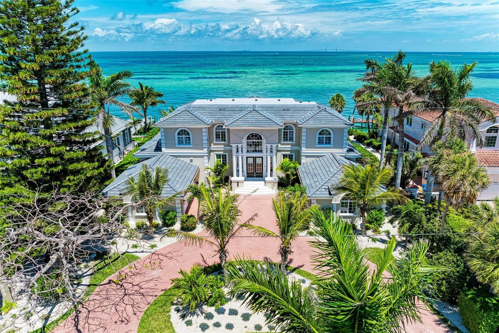 TOTAL RENOVATION from new floors to new roof and everything in between! Spectacular, Luxury Estate with a panoramic vista of Anna Maria Sound and Tampa Bay, the Skyway Bridge and the twinkling lights that playfully dance across the water. New Wine Room and Wine Bar for those accustomed to the finer things in life. A grand entry features a circular brick paver driveway, well-manicured landscaping, stone staircase and impressive columns with double door entry. With over 5,000 square feet, 4 bedrooms/4.5 baths, grand living spaces, office, and lovely bay front terraces allow for palatial living. Additional rooms could be used to create 5-6 bedrooms. Built by Whitehead Construction, the home's exterior features outdoor entertaining areas, a heated pool and spa, deep water boat dockage with a 14,000 pound boat lift, garages to accommodate 4 cars, and ever engaging water views. The rolling greens of the Key Royale golf course are just steps from the front door. All of this and more on a 7 mile Gulf Coast barrier Island named one of the Best Beach Towns in America. SOLD Professionally Turn-key Furnished and Decorated.
