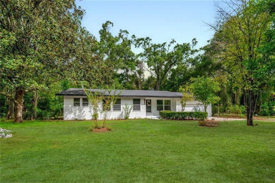 This 4 bedroom, 3 bathroom home sits on a 0.69 acre lot in High Springs and offers a comfortable blend of space and function. A large mudroom with a full bath adds flexibility, while recent updates provide peace of mind with a new roof, new AC, and new LVP flooring. The kitchen features quartz countertops and quality cabinetry, and the master suite includes dual closets and private entrance to back porch. Natural light fills the living spaces through large windows and a sliding glass door that open to a generous private back porch. The shaded yard is accented with mature trees, fruit trees, and an herb garden, creating a private setting to enjoy. A two car garage completes the property. Conveniently located near downtown High Springs and just minutes from the Santa Fe River and local springs. (Listing agent has ownership of this home.)