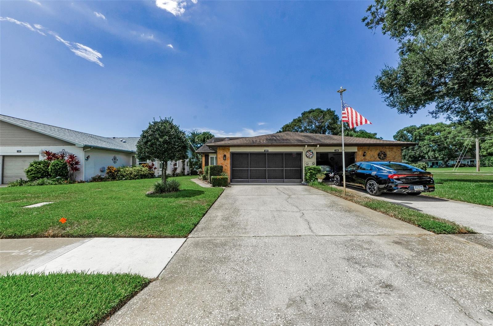 Welcome to this updated 2-bedroom, 2-bathroom villa located in Highland Lakes, Palm Harbor’s active 55+ golf community. Offering 1,332 sq ft of living space with a split floor plan, the home includes vaulted ceilings, new tile throughout the home, and brand new carpet in the primary bedroom, fresh interior paint, and new HVAC unit with replaced ductwork. The two-car garage has also been freshly painted and features a screened enclosure suitable for hobbies or relaxing.
The updated kitchen provides solid cabinetry, a built-in pantry, generous counter space, and newer appliances. The primary suite includes ample closet space and a walk-in shower. The rear of the property backs to green space and a pond view with no immediate rear neighbors.
Duplex Village II has a monthly fee of $163, covering cable, internet, lawn care, irrigation, trash, recycling, and pest control. The Highland Lakes master association fee is $164/month and includes unlimited golf on three private executive courses, tennis, pickleball, bocce, shuffleboard, a clubhouse with fitness classes and events, and a lodge on Lake Tarpon with a private boat ramp, fishing pier, and community pontoon boats. Residents also have access to RV and boat storage, and the entire neighborhood is golf cart-friendly.
This home is located in a non-flood zone, non-evacuation zone and above the flood plain. Conveniently close to shopping, dining, medical facilities, beaches, and Tampa International Airport.