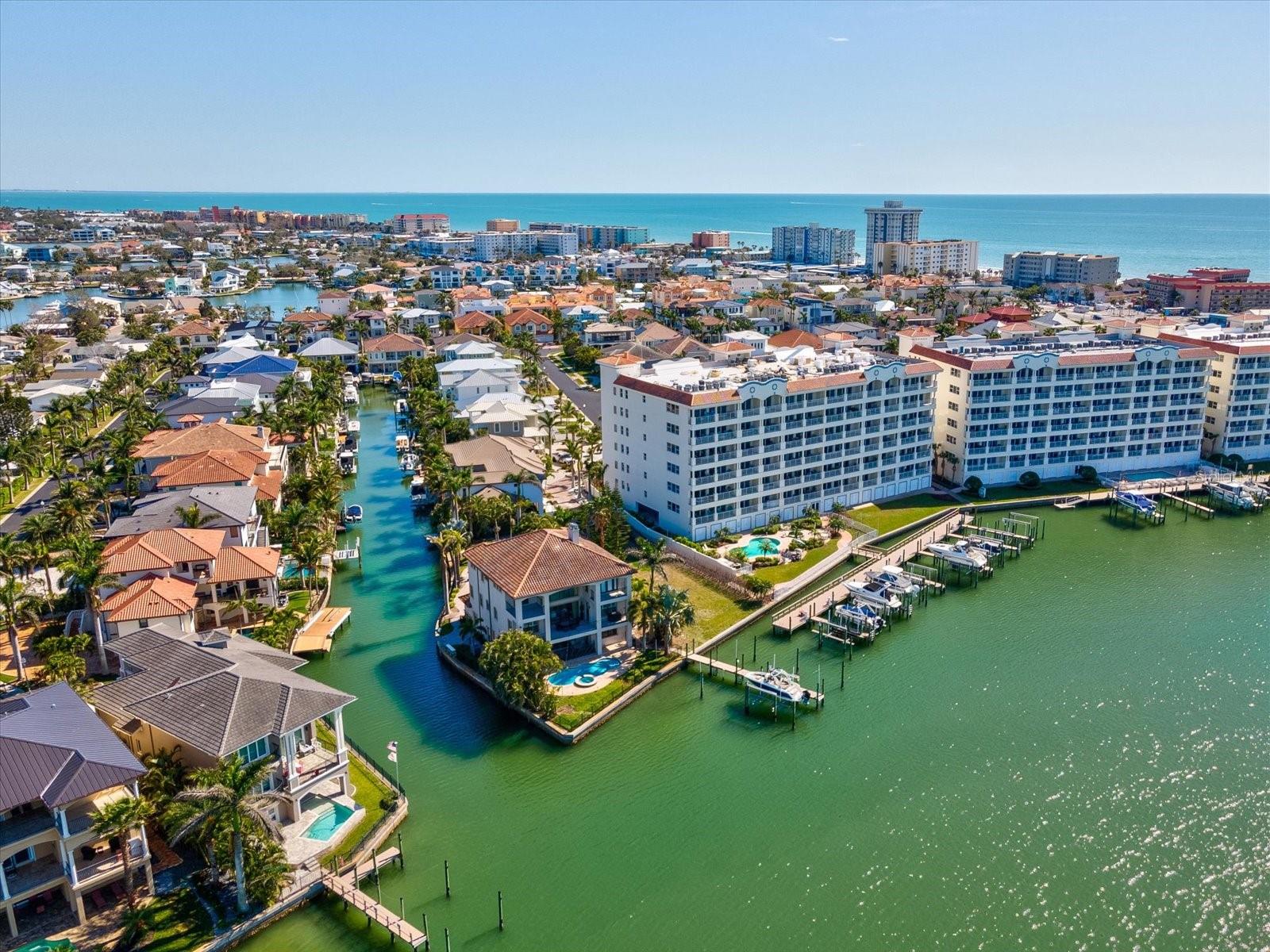 Welcome to paradise in this stunning 6th-floor corner unit at the exclusive, guard-gated Redington Shores Yacht & Tennis Club. With over 3,000 square feet of beautifully designed living space, this 3-bedroom, 3.5-bath condo offers panoramic water views and a 45-foot balcony with floor-to-ceiling impact glass sliders, accessible from both the living room and the primary suite. Inside, the open-concept layout features a gourmet kitchen with granite countertops, built-in oven, and microwave. Each spacious bedroom includes its own en-suite bath and walk-in closet. A separate den with an attached half bath adds versatility for a home office or flex space. A large walk-in laundry room provides additional storage and everyday convenience. This unit includes two rare, assigned covered parking spaces and a private waterfront storage cabana—perfect for beach gear or paddleboards. Enjoy resort-style amenities including heated pools, spa, tennis courts, fitness center, elegant clubhouse, a waterfront boardwalk, and 24/7 security. With the beach just steps away across Gulf Blvd, this is your opportunity to live the ultimate Florida coastal lifestyle.