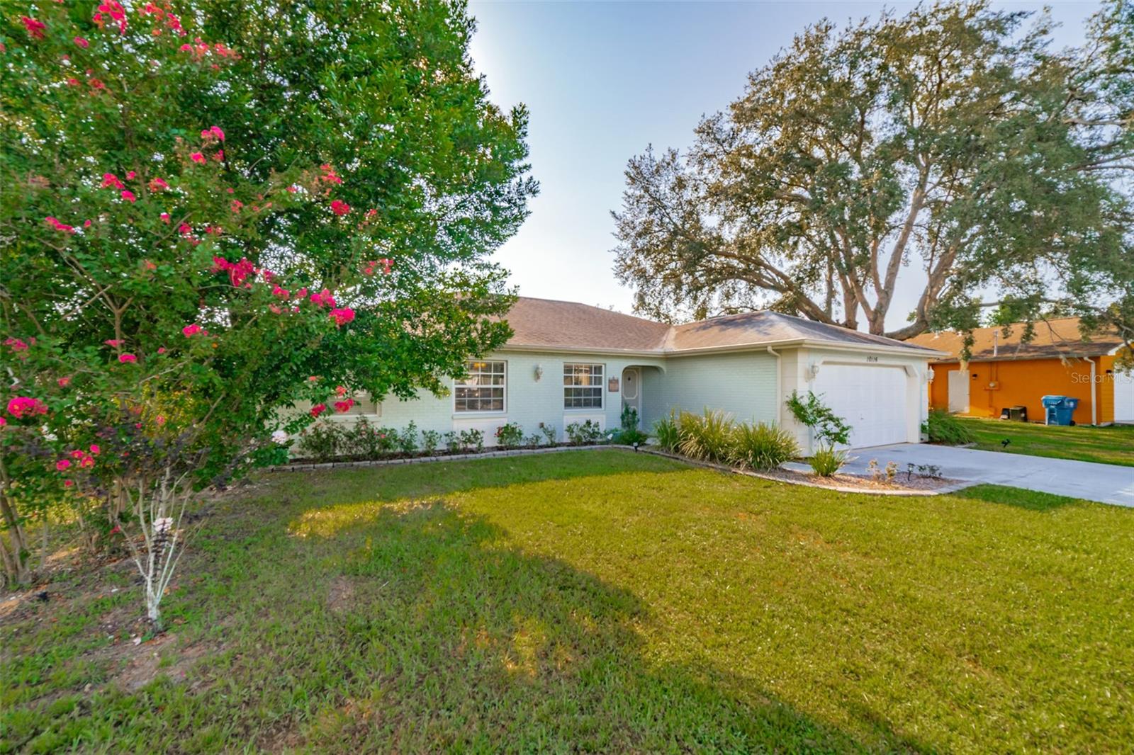 Charming and beautifully cared for three-bedroom, two-bath home situated in the heart of Spring Hill. This home features fresh paint and luxurious vinyl flooring throughout. The kitchen boasts a brand new stove, wooden cabinets, an island with a sink, and ample space for bar stools. Additionally, there is a closet pantry and a coffee bar area. This open-concept kitchen provides space for a cozy dining area and a family room. Adjacent to the kitchen is a flexible space that can serve as an extra dining area, an office, or a playroom, complete with sliding glass doors that open to an enclosed patio, which leads to a beautifully maintained oversized backyard featuring a newer PVC privacy fence. An outdoor patio includes a path that guides you to a fire pit area, all constructed with pavers, perfect for enjoying quiet evenings under the stars. The fence is adorned with mature plants including 2 blueberry bushes that produce fruit enhancing the view. All three bedrooms are generously sized, complete with closets, while the master suite includes its own spacious bathroom. Both bathrooms have been updated. On the way to the two-car garage, you will find the laundry room, which includes closet storage, a large laundry sink, and a washer and dryer, with extra space for shelving and more. This lovely home is conveniently located off Spring Hill Drive and is just a short distance from shopping, medical facilities, restaurants, a waterfront park, and the expressway leading to Tampa.