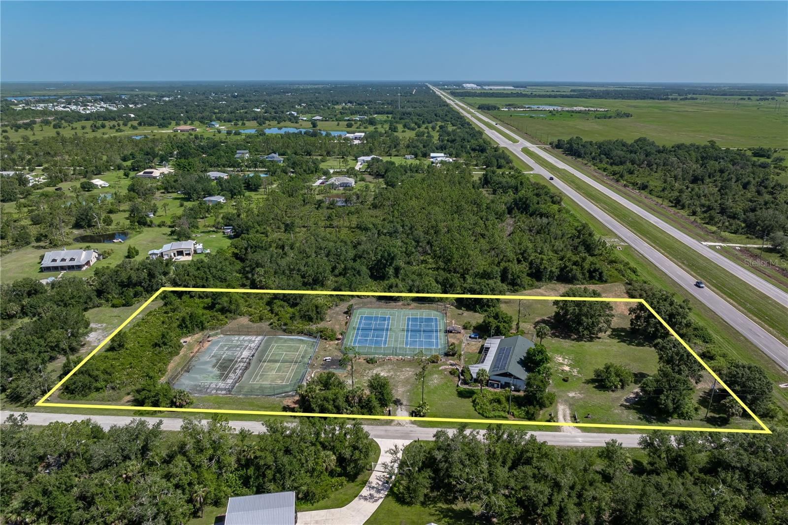 RARE ACREAGE OPPORTUNITY IN PUNTA GORDA W/PRIVATE TENNIS FACILITY ON 4.59 ACRES -- This unique, 3 bed/4 bath property w/**NEW ROOF** offers nearly five acres & delivers a lifestyle opportunity unlike anything currently on the market. Zoned rural residential, it offers privacy, space, and versatility—whether you're seeking a private retreat, recreational estate, or long-term development project. The grounds feature four, fenced tennis courts w/two of the courts featuring the overlay for 8 pickleball courts. Property provides a dream setup for the serious player, coach, or anyone envisioning their own at-home racquet sports facility. While current zoning does not allow for income-producing use, the layout and infrastructure provide a compelling starting point should a future buyer want to explore a zoning change. At the heart of the property sits a single-story residence w/cathedral ceilings & an open layout. The main portion of the home offers two large bedrooms - each w/en-suite baths, a spacious great room and a bonus room located just off the master suite that would make a great home office, gym or art studio. A wide lanai spans the back of the home, creating a natural extension of the living space. It's the perfect spot to kick back and relax while overlooking the tennis courts. From the lanai, you'll find the 3rd bedroom w/en-suite bath plus an additional bathroom. The 3rd bedroom was previously used as the pro-shop w/the two bathrooms being used as his & her locker rooms. It’s a rare setup with countless possibilities—guest quarters, studio, home gym, or business office with private entry. A two-car garage adds storage and practicality, while mature palms, native vegetation, and open lawn areas make the exterior both lush and usable. While the property does need cosmetic updates, the structure, layout, and location provide an exceptional canvas for those seeking elbow room, income potential, or a private compound w/an idyllic country setting. This is a property that welcomes vision. Whether your passion is tennis, pickleball, privacy, or you are just interested in acreage with a prime location where you can add gardens, stables, or even a second residence (subject to zoning), this a truly rare offering in Southwest Florida. Located on US17/Duncan Rd & just minutes to US-41 & I-75, you can reach downtown Punta Gorda or historic Arcadia in short order where you'll find plenty of shopping and dining options. This location balances the country feel with convenient access to all the area amenities. Explore the possibilities. There’s nothing else quite like it on the market. Schedule an appointment today.