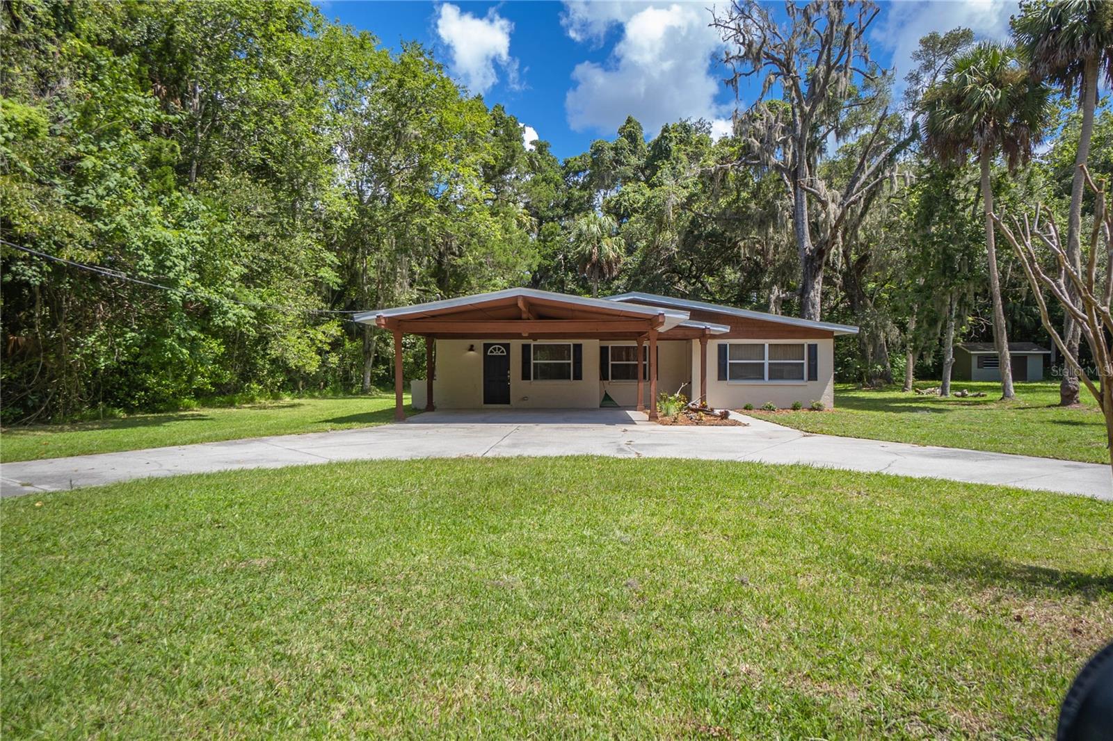 Absolutely charming 3/2 with 1674 square feet of living space nestled on a generous .44-acre parcel in the desirable Woodland Estates Community. Home features a roomy living and dining room combination, perfect for everyday life or entertaining, updated bathrooms & kitchen with white wood cabinetry, granite countertops, breakfast bar, and appliances. Additionally, the home includes a versatile flex room complete with a kitchenette and built-in shelving—ideal for a guest suite, office, or creative space, primary suite with walk-in closet and bathroom. Outdoors present a custom attached double carport, a spacious rear screened patio, circular driveway, storage shed and updated roof & AC. As a resident of Woodland Estates, you’ll also enjoy access to a community boat ramp in lieu of busy public locations, offering easy access to the area's scenic waterways. Don’t miss your opportunity to secure an affordable and move-in ready home for $250,000.