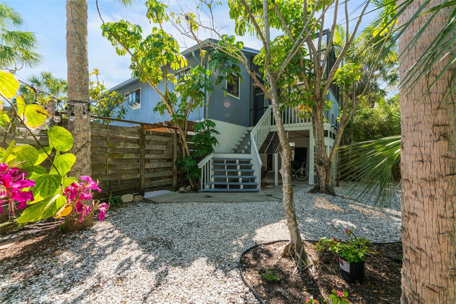 Just a short two-block stroll from Siesta Key's vibrant village, you'll find yourself surrounded by a delightful array of casual and fine dining restaurants, lively shops, and bars with nightly live music. Yet, this charming home is nestled in a peaceful, quiet neighborhood; offering the perfect blend of convenience and tranquility. Enjoy the best of both worlds with a short walk or bike ride to the renowned Siesta Key Beach, and directly across from the Canal, where you can add your own private dock and launch your boat, kayaks, or paddleboards. Glide out to the Intracoastal and experience the water from your own yard! This home is spacious and inviting, with plenty of updates to enhance its charm! Upstairs, you'll find 2 bedrooms and 2 baths, including a recently remodeled kitchen with bright shaker-style cabinets and sleek quartz countertops. Skylights and large windows allow abundant natural light to pour in, making the entire home feel airy and bright. Cozy up by the real wood-burning fireplace in the open living and dining area, where the space flows seamlessly to the outdoors. Step out onto the large composite wood deck with modern aluminum railings, where you can enjoy tree-top views of the yard and canal—perfect for entertaining or relaxing. Off the kitchen, a second porch offers a peaceful retreat to sip your morning coffee while enjoying the sounds of birds singing. Downstairs you'll find your laundry room with a new washer and dryer, a new tankless water heater, and a large storage room. The additional bonus room would make an ideal place for a gym, game room, or media center. The beautiful, low-maintenance epoxy flooring keeps the downstairs bright and inviting. The large corner lot offers plenty of room to create your dream backyard, with ample space for a pool if you choose. The yard is perfect for hosting BBQs, oyster roasts, and making memories with friends and family. There’s also an extra storage shed beneath the second-story deck, keeping your lawn equipment out of sight and neatly organized. A concrete patio underneath adds even more entertaining space. Experience the relaxed, resort-style living you’ve always dreamed of—right in the heart of Siesta Key. Every day feels like a vacation in this coastal gem!