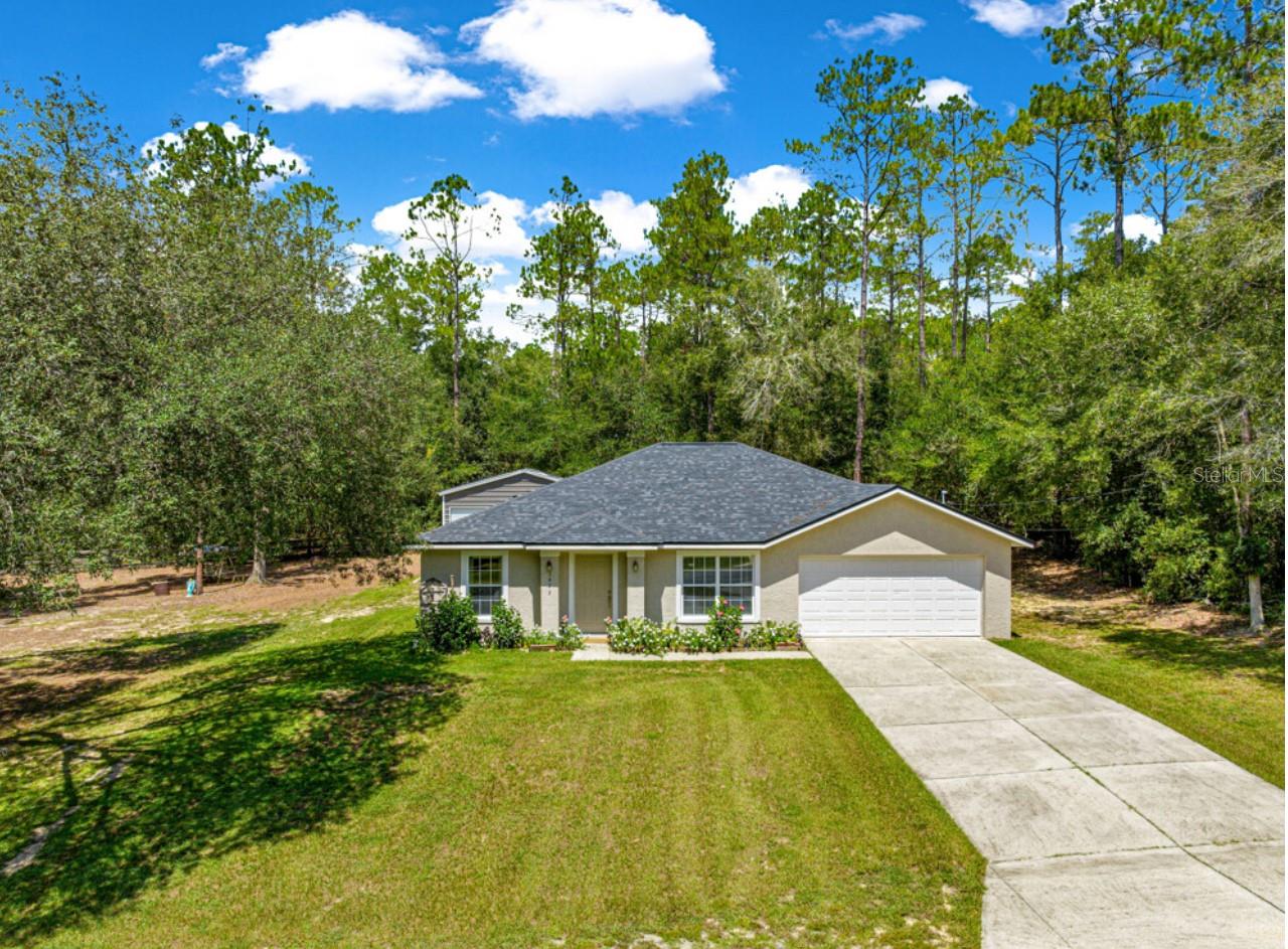 Enjoy spacious, comfortable living in the heart of Citrus Springs on a generous 0.52-acre corner lot in a desirable No HOA community. This 3-bedroom, 2-bath 1,534 sqft home features an attached 2-car garage and a large living room with vaulted ceilings, flowing seamlessly into a kitchen with two pantries, ample cabinet space and a breakfast bar. The primary suite is conveniently located off the kitchen and includes a walk-in closet and en-suite bathroom with a separate shower. The split floor plan provides privacy for guests, with two additional bedrooms on the opposite side of the home and a full guest bathroom situated between them. Outdoor living is enhanced by a covered back porch, a large concrete patio area perfect for entertaining or relaxing with beautiful landscaping including banana trees, creating a private and serene environment. A detached 24 x 25 garage/workshop built in 2021, features a loft for storage, 200amp panel and dedicated solar panels installed in 2022. This home is conveniently located near shopping, restaurants and everyday amenities will still just a short drive to the Gulf Coast for fishing, boating & snorkeling adventures. The roof was replaced in 2024 and a 1-year home warranty will be included at closing, providing added peace of mind. With thoughtful design, energy-efficient features and functional living spaces, this property is ideal for families or anyone seeking convenience, and flexibility in a prime Citrus Springs location. Schedule your private showing today!