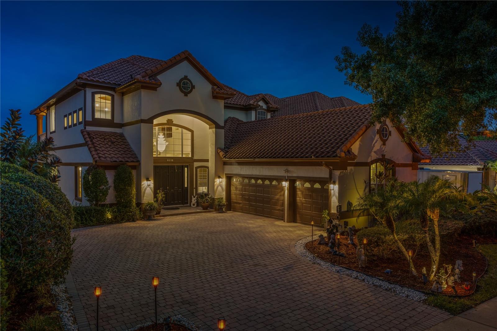 Stunning three-story lakefront residence located in the 24-hour guard-gated community of Vizcaya. Perfectly positioned along the shores of Big Sand Lake, this luxurious home is near Restaurant Row with a multitude of shopping and dining options. As you step through the front door, your eyes are immediately greeted by soaring two-story ceilings and a grand staircase leading to the second floor. The open kitchen features top-of-the-line stainless steel appliances and custom cabinetry with a view of the expansive family room and a wall of windows with breathtaking views of the lake. The primary suite is located on the first floor and includes a sitting area with water views and a luxurious bath with a walk-in shower and soaking tub that is sure to melt away the stresses of the day. On the second floor, you will find three additional bedrooms, a bonus room, a media room and a large outdoor balcony. The lower level is perfect for entertaining with the huge game room, custom bar and a guest suite with its own bath. Exterior amenities include a sparkling pool, hot tub and an extended outdoor patio with unparalleled lake and skyline views. For the auto enthusiast, there is an oversized three-car garage and a large driveway for additional parking. The home is positioned so you get the vibrant colors of sunset and sunrise every day. Vizcaya features an amenity-rich environment with a clubhouse, fitness center, tennis courts, community pool and sidewalks throughout the neighborhood for a relaxing early morning stroll. The location simply can’t be beat, near to some of Orlando’s best restaurants and a short drive to world-class shopping and all the area theme parks. Don’t miss your opportunity to own this amazing lakefront home.