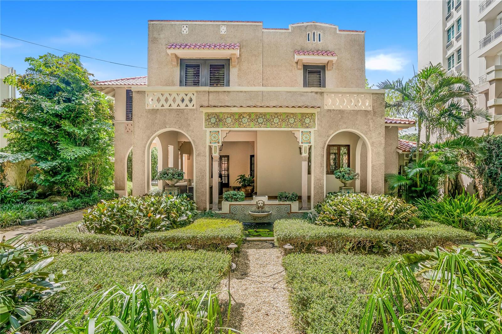 A piece of art in the iconic Spanish Revival style, this villa was meticulously crafted in the 1930’s by esteemed architect Pedro Adolfo de Castro. The historic gem spans 4,006 square feet of living space, featuring 5 beds/3.5 baths over two buildings. Located just one block from the widest expanse of beach on the most desirable residential block between Ocean Park and Condado, the property sits on a massive 1099 square meter lot. The land benefits from RT3 zoning, presenting a unique development opportunity. Whether inhabiting this cultural marvel or developing a larger structure, it must be seen and experienced.
A vast Moroccan garden with water feature and lush landscaping greets visitors with dramatic flourish. As you approach the main entrance - look closely - tiny shells have been incorporated into the entire facade offering a glimpse of the intricacy that awaits.
Open the front door and witness the sophistication of the interiors, featuring 12-foot ceilings, grand Spanish-style arches, original Terrazzo flooring with ornate bronze seams, custom mahogany woodwork, and Spanish wrought iron. The formal entry and living room are surrounded by windows, continuing the harmonious flow of the tropical gardens outside.
Behind this grand reception room, a powder room with beautiful stained-glass windows, is conveniently located for visitors. Walk down the hallway, ornamented with immense arches for an aura of grandeur, to the formal library. Adjacent you’ll find a tremendous walk-in climate-controlled wine cave.
The kitchen is conveniently located nearby and harkens to colorful, classic Puerto Rican cuisine, while equipped with stainless steel and all modern appliances. Connected to the kitchen is the informal dining area and wet bar.
Float to the elegant formal dining room where a massive floor to ceiling window bathes the space in light. This accent window offers a new vantage point to witness the breath-taking sculpture garden and mosaic fountains outside, making for the most exquisite dining conversation.
A grand bronze staircase ascends to the second level where you will discover the home’s 3 beds/2 baths, home office, and truly unique Moroccan sitting room.
The expansive primary suite is a private sanctum of elegance and sophistication. Throw open the French doors to a romantic Juliette balcony overlooking the front garden below. Soak in the jacuzzi tub, an entire spa room apart from the ensuite bathroom for the ultimate in relaxation.
A distinct walking bridge from the second floor leads to an additional recently remodeled living quarter, which includes 1 bed/1 bath, an office space, and a large area currently serving as an art gallery.
From this level, ascend the grand outdoor spiral staircase, itself an architectural masterpiece, to view sunsets from the roof, or descend a second spiral staircase to the grounds below. The black bottomed pool, surrounded by mature tropical landscaping, is designed as both a beautiful focal point and for use and enjoyment.
This entire residence is completely gated for the utmost security, while the driveway leads to an enclosed, private three-car garage. The property is equipped with an automatic Generac-Diesel 30 KLV generator and a 600-gallon water cistern, ensuring uninterrupted convenience.
This home seamlessly blends contemporary amenities with preserved original elements, situated on one of the largest and most rare lots in Condado. Contact me today.