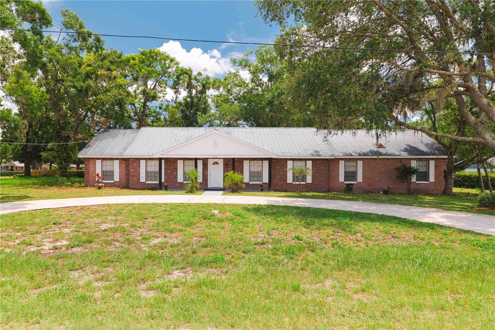 This house has 5 bedrooms and 3 bathrooms, including a spacious mother-in-law apartment with two bedrooms and one full bathroom. The house also has a large, covered, enclosed back porch with window air conditioning. The main house is entered through a wonderfully spacious area, which includes the living room, dining room, and kitchen. The fully remodeled, modern kitchen with new cabinets and granite countertops features a refrigerator, stove, microwave, dishwasher, and garbage disposal. Additionally, the former parking area was enclosed, creating an additional space that can serve as a bedroom, study, or office. There is also a laundry area there, with a washer and dryer. The mother-in-law apartment, with a separate entrance, opens onto an integrated living room, dining room, and kitchen space and also includes a refrigerator, stove, dishwasher, microwave, and laundry area. The house has rear exits, allowing you to enjoy the spacious green areas with lush oak trees and other species, from the master bedroom, the porch, and the mother-in-law's apartment. The building has a septic tank and private well, so there are no water bills or HOA dues. All these features in a fully remodeled home make this the ideal property to enjoy in this coveted area of Tampa.