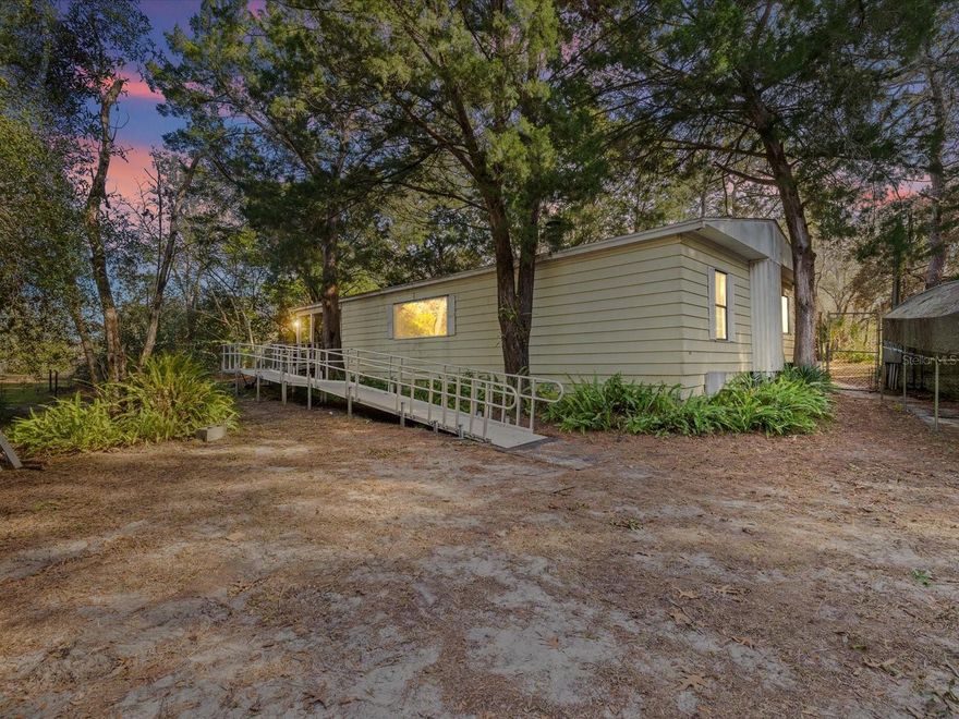 Opportunity awaits with this 3-bedroom, 2-bath double-wide manufactured home situated on 1.2 fully fenced acres offering space, privacy, and endless potential. This property has good bones, a functional layout, split floor plan, and great square footage, making it an ideal option for investors, renovators, or buyers looking to create their own private retreat.  ROOF 2019, HVAC 2019, Well Pump 2021, Drain Field 2022.  Enjoy both front and back decks overlooking a private yard, perfect for relaxing, entertaining, or expanding outdoor living space. The property also features a carport and a shed with workshop, providing ample room for storage, hobbies, or tools.  Metal ramp will be removed and replaced with wooden stairs before closing.  Located with no HOA and no flood zone, this home offers flexibility and freedom rarely found. Conveniently positioned close to the highway, hospitals, schools, shopping, and grocery stores, you’ll enjoy easy access to daily essentials while still having the peace of acreage living.  Being sold as-is and ready to make it your own—this is a fantastic value-add opportunity with strong upside potential.