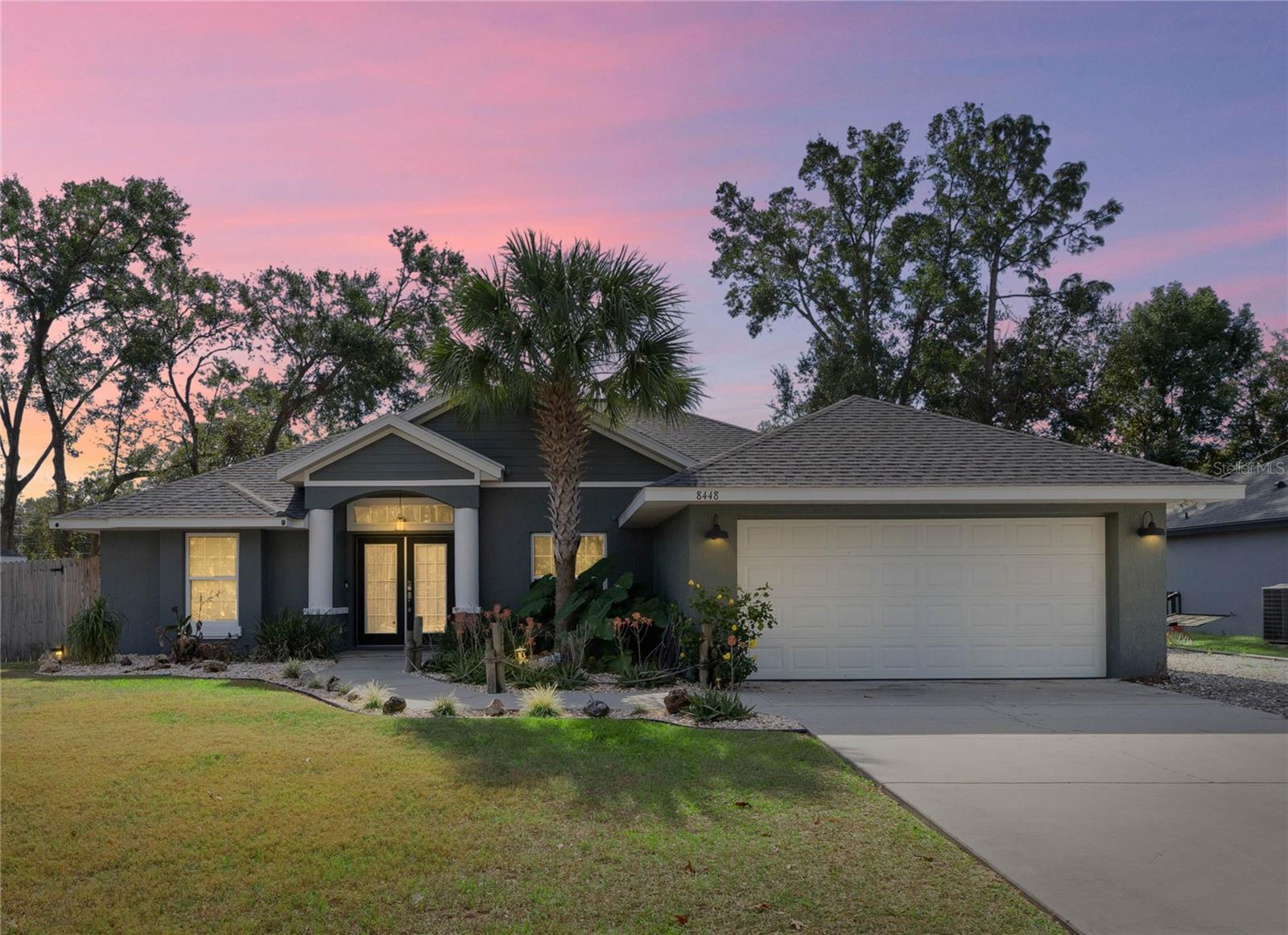One or more photo(s) has been virtually staged. GOLF CART TO THE VILLAGES! Discover the perfect combination of outdoor living and convenience in this well-maintained 4-bedroom, 2-bathroom home featuring a spacious outdoor area designed for the ultimate in entertaining or relaxing. Best of all, you can access all The Villages has to offer without ever stepping into your car – simply hop in your golf cart and ride to nearby dining, shopping, and entertainment, all just moments away.
Step inside and be greeted by a spacious, open floor plan designed for both everyday living and grand entertaining. The expansive kitchen features beautiful granite countertops, abundant storage, stainless appliances and cabinetry lighting. A large picture window provides stunning views of the fenced backyard, creating a seamless connection between indoor and outdoor living. Each of the four bedrooms is generously sized, with plenty of closet space. The master suite is a true retreat, offering privacy and luxury with dual vanity sinks, a relaxing soaking tub, and a separate shower. The air-conditioned garage, featuring recessed lighting and a professionally installed epoxy floor coating, offers the ideal space for a workshop, home gym, or the ultimate man cave. Step outside to your backyard oasis where there is more professionally installed epoxy floor coating in the oversized covered lanai that features a wall-mounted TV and outdoor lighting, creating an inviting space that elevates your outdoor experience. Don’t miss this exceptional opportunity to own a home that showcases the best of Florida living with effortless golf-cart access to The Villages, free from HOA restrictions or monthly fees.