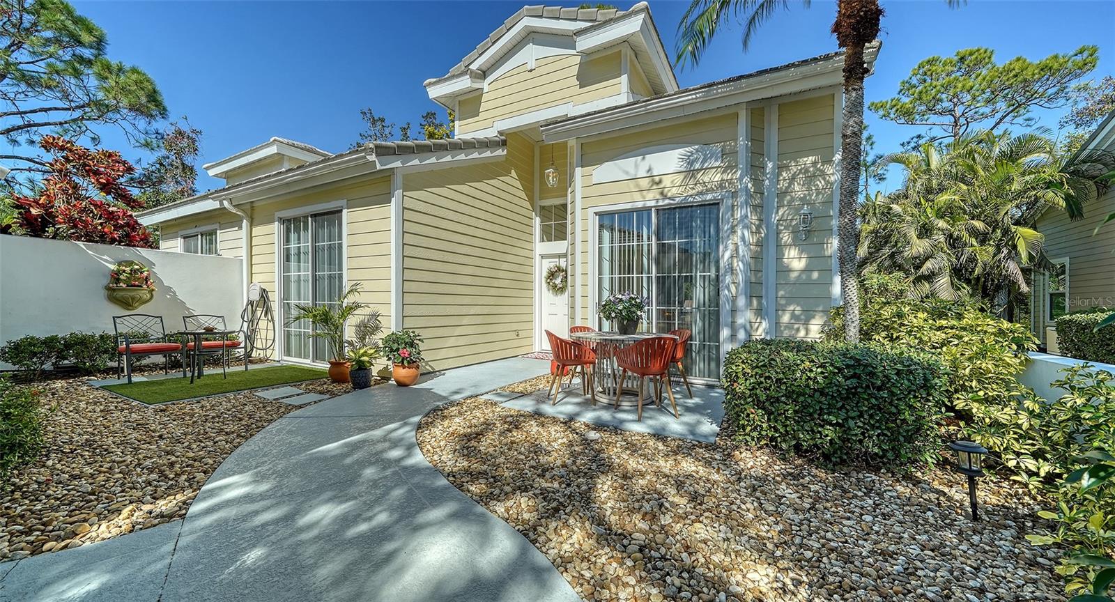 Discover the perfect blend of comfort, style, and outdoor living in this 2-bedroom, 2-bathroom, 2-car garage villa nestled within the award-winning University Park Country Club. As you approach, a beautifully pavered walkway leads to a charming concrete and stone courtyard, an ideal space for entertaining or quiet relaxation. The welcoming front entrance, adorned with glass sidelight and transom window, opens to a bright and thoughtfully designed living area featuring tile and laminate flooring, soaring ceilings, and an effortless flow throughout.
The spacious kitchen boasts a breakfast bar and direct access to the courtyard through a double slider, perfect for enjoying your morning coffee al fresco. The adjacent dining room is enhanced by a delightful window seat, while the adjacent living room features triple sliders that open to a glass-enclosed lanai, allowing you to enjoy Florida’s beautiful weather all year long. Beyond the lanai, quad-sliders and screens lead to an additional wooden deck and a serene backyard retreat.
The spacious primary suite features a sitting area and double sliders to the enclosed lanai. The ensuite bath offers double sinks, a walk-in shower with a bench, and a spacious walk-in closet with built-in storage. The guest bedroom also provides access to the courtyard through double sliders and includes a generous walk-in closet. Visitors will appreciate the private bath with a tub/shower combination, and a separate door ensures added privacy for the entire guest area. The furnishings could be available if you wish to make this property completely turn-key.
Whitebridge Court is renowned for its maintenance-free lifestyle and boasts a community pool within short distance of this home. Just across the street, the University Park Country Club stands as one of Florida’s top-ranked golf communities, featuring 27 holes of championship golf, tennis and pickleball courts, a fitness center, croquet, and an array of social and group activities.
This peaceful enclave is ideally situated just 15 minutes from downtown Sarasota, where you’ll find premier shopping, arts and theater, museums, fine dining, and top-ranked healthcare. Nearby, the University Town Center offers over 300 shops, restaurants, and attractions, while easy access to I-75 ensures seamless travel. For outdoor enthusiasts, Nathan Benderson Park—home to world-class rowing events—is just two miles away.
Residents of University Park Country Club enjoy access to club amenities with a required minimum Social Membership, ensuring a vibrant and active lifestyle in this exceptional community.
Don’t miss this opportunity to make this lovely villa your new home!