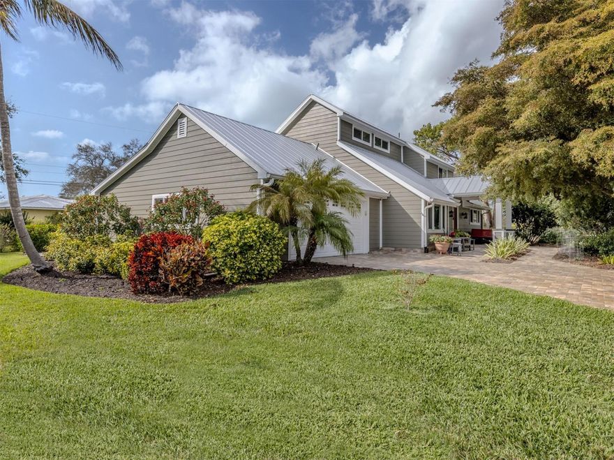 To view this custom Island home, try to set aside plenty of time to go through it twice. The expansive size, unique layout and many upscale details are a lot to take in by just a casual walk-through.
Among first impressions are the paver drive and walkways, mature trees and plantings, and welcoming front porch entry.  The inside space flows beautifully revealing one thoughtful detail after another. The heart of the home is the kitchen. An extra-size granite-topped island includes bar-height seating and another seating perch faces inward. The list of appliances shows only the best, starting with 60-inch gas +electric range by Wolfe, restaurant-grade double-size refrigerator and freezer, two full size Fisher & Paykel dishwasher drawers, under counter Sub-Zero ice maker and bar fridge. For anyone who appreciates the Art of cooking, it's a dream come true. Beyond the second dining area is the 20x20 2-story great room, with customized fireplace wall, structural beamed ceiling The wall of double-stacking sliding doors opens to the Outdoor Family Room. With screened enclosure on 3 sides, lovely pine ceiling and tile floors, it truly feels like a bonus family room.    The main floor also includes 2 bedrooms and bath on their own side of the house. The primary suite is a true retreat, consisting of the whole 729 sq.ft.2nd floor.  Accessible by 2 sets of stairs, the first section is a 16x18 office/library with vaulted ceiling that overlooks parts of the main floor and even a special closet for extra stack washer & dryer. The adjacent loft has 7x23 loft workout section, and access to a 12x18 outdoor deck. The main bedroom is a quiet and secluded space with adjacent bath with multiple-room and extravagant closet spaces. This one-of-a-kind Venice Island home goes beyond looking great, it features mechanical systems including a whole-house Generac generator, 1000-gallon propane tank, two tankless instant-hot water systems, hurricane-rated windows, replumbed water pipes and re-lined sewer pipes and more. Ask for a comprehensive list of all value-add items.