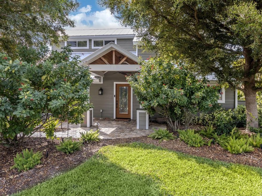 To view this custom Island home, try to set aside plenty of time to go through it twice. The expansive size, unique layout and many upscale details are a lot to take in by just a casual walk-through.
Among first impressions are the paver drive and walkways, mature trees and plantings, and welcoming front porch entry.  The inside space flows beautifully revealing one thoughtful detail after another. The heart of the home is the kitchen. An extra-size granite-topped island includes bar-height seating and another seating perch faces inward. The list of appliances shows only the best, starting with 60-inch gas +electric range by Wolfe, restaurant-grade double-size refrigerator and freezer, two full size Fisher & Paykel dishwasher drawers, under counter Sub-Zero ice maker and bar fridge. For anyone who appreciates the Art of cooking, it's a dream come true. Beyond the second dining area is the 20x20 2-story great room, with customized fireplace wall, structural beamed ceiling The wall of double-stacking sliding doors opens to the Outdoor Family Room. With screened enclosure on 3 sides, lovely pine ceiling and tile floors, it truly feels like a bonus family room.    The main floor also includes 2 bedrooms and bath on their own side of the house. The primary suite is a true retreat, consisting of the whole 729 sq.ft.2nd floor.  Accessible by 2 sets of stairs, the first section is a 16x18 office/library with vaulted ceiling that overlooks parts of the main floor and even a special closet for extra stack washer & dryer. The adjacent loft has 7x23 loft workout section, and access to a 12x18 outdoor deck. The main bedroom is a quiet and secluded space with adjacent bath with multiple-room and extravagant closet spaces. This one-of-a-kind Venice Island home goes beyond looking great, it features mechanical systems including a whole-house Generac generator, 1000-gallon propane tank, two tankless instant-hot water systems, hurricane-rated windows, replumbed water pipes and re-lined sewer pipes and more. Ask for a comprehensive list of all value-add items.