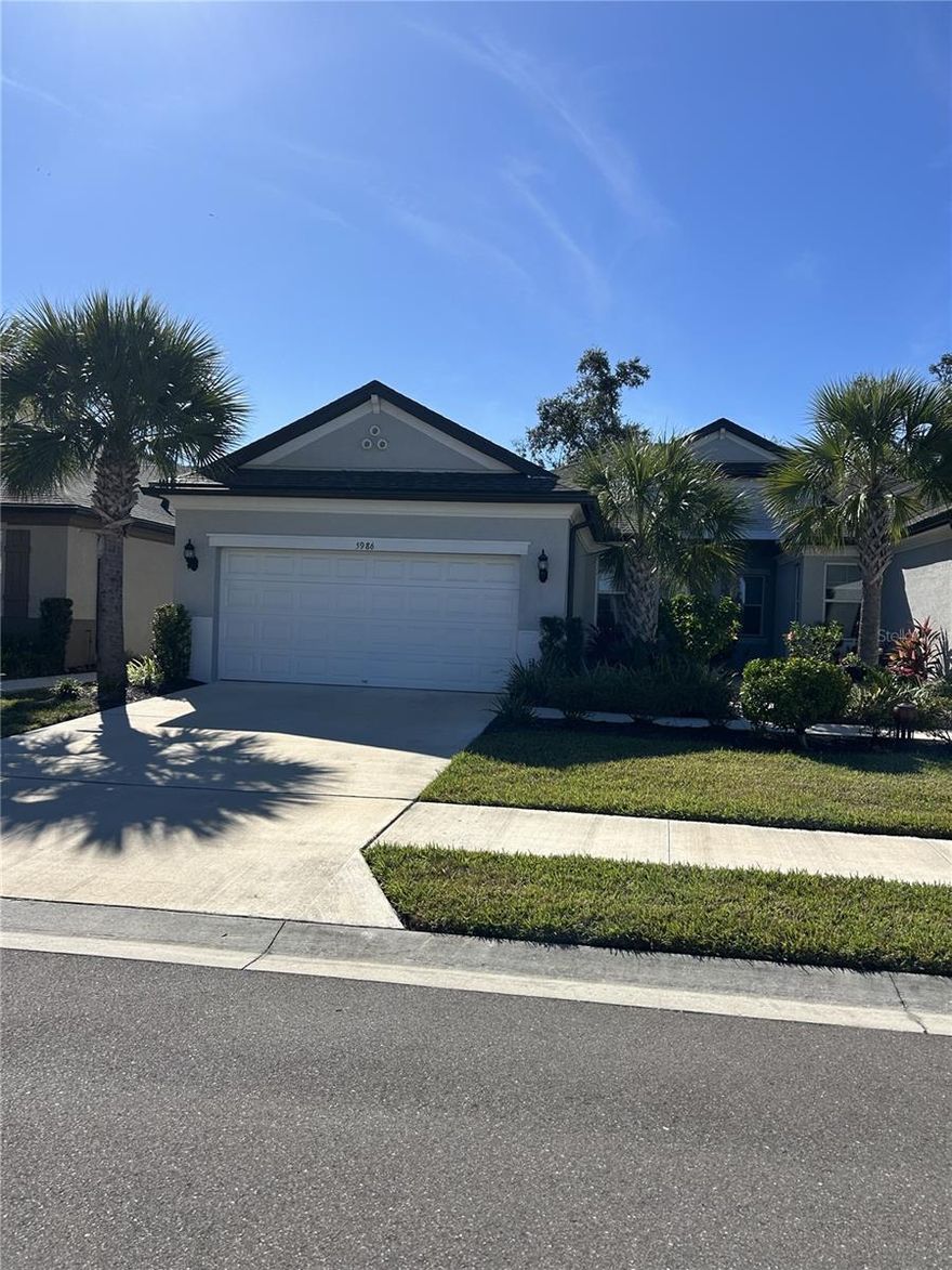 Welcome to Amberly- a cozy, maintenance-free community! Discover the perfect blend of comfort, coastal living and convenience in this move-in-ready 3-bedroom, 2-bathroom villa with a 2-car garage. Located in the sought-after gated community of Amberly, this M/I home offers a low-HOA, no-CDD, maintenance-free lifestyle just minutes from I-75 and the beautiful Gulf Beaches of Anna Maria Island. Go inside the inviting foyer that opens into a spacious living area with high ceilings and ceiling fan, plantation shutters and ceramic tile floors throughout the main living spaces. The modern kitchen features  cabinetry, quartz countertops, pendant lighting, stainless steel appliances, and a walk-in pantry. Enjoy your morning coffee or evening relaxation on the screened lanai with sun shade overlooking a private backyard with wooded views offering peace and privacy. The primary suite includes a walk-in closet and a luxurious ensuite bathroom with a double vanity, quartz countertops, and a walk-in tiled shower with bench. A second and third bedroom can share a full bath with a tub/shower combo. A spacious laundry room with shelving and rarely used Washer and Dryer included leads to a 2-car garage featuring epoxy flooring and storage space. Residents of Amberly enjoy access to a beautiful heated community pool, scenic pond views, and the ease of maintenance-free living.