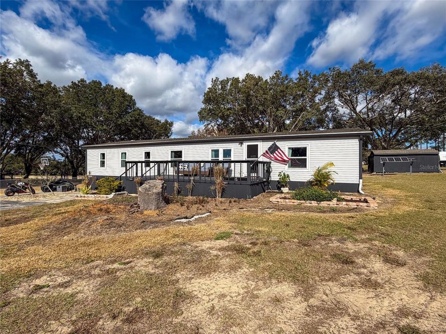 Welcome to your own private homestead, offering peaceful living while remaining close to everything Central Florida has to offer, in this beautiful Davenport, Florida home. Set on nearly one acre of fully usable, fenced land with NO HOA and NO CDD agricultural zoning, this extensively upgraded property offers freedom, functionality, and space for animals, gardening, RVs, or future expansion. The 4-bedroom, 3-bath home spans 1,820 square feet and has been thoughtfully renovated over the past five years, including new windows, all-new drywall with knockdown ceiling texture, updated electrical outlets and switches, crown molding in all main living areas, wainscoting in the living room, dining room, and butler’s pantry, and durable LVP flooring throughout the kitchen, hallway, living room, and one bathroom. The renovated kitchen features granite countertops, soft-close custom blue cabinetry, a workstation sink, modern appliances all under five years old, and saloon doors leading into the butler’s pantry, while the open layout is enhanced by new ceiling fans, including one Alexa-enabled. The split-bedroom floor plan offers privacy, with the primary suite showcasing an updated bathroom with a replaced shower, painted cabinetry, new exhaust fan, new toilet, and a stylish barn door, complemented by all-new PEX plumbing and an owned water softener. Additional improvements include all new toilets, washer and dryer under five years old, replaced sliding door, surge protector on the HVAC system, and Ring spotlight cameras at the front and back of the home. Outside, the property features concrete siding skirting, a freshly painted exterior, recently replaced and painted front deck, newly built and painted back deck, and an 18-foot above-ground pool with manufacturer filter located just off the deck. The land has been professionally cleared with trimmed tree lines and removed trees, includes a well on the vacant lot, and offers a workshop with replaced wood siding, added lean-to, and an outdoor sink with lumber countertop, while the septic system was serviced just two months ago. All of this is paired with a highly convenient location, just minutes from I-4 and Highway 27, approximately 10–12 minutes from shopping, dining, and entertainment at Posner Park, close to everyday conveniences in Haines City, near the dining, golf, and retail options of ChampionsGate, and within easy reach of Walt Disney World Resort, Orlando, Lakeland, and Tampa—delivering the perfect blend of privacy, upgrades, and accessibility.
