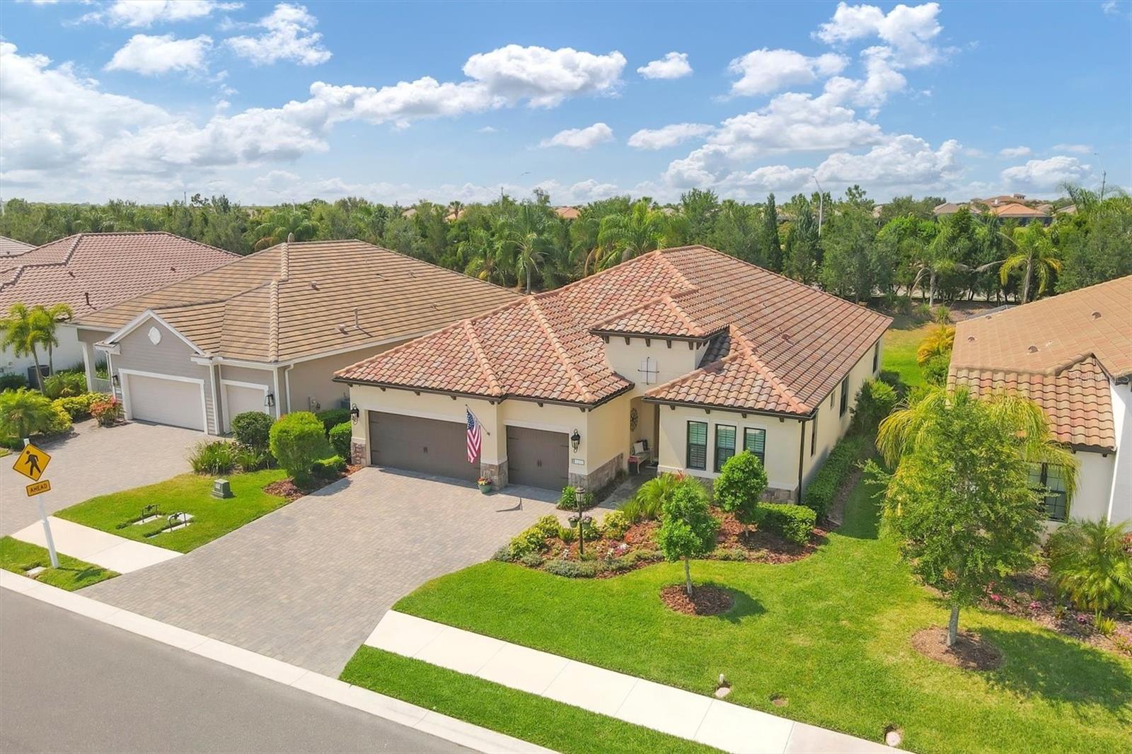 MODEL QUALITY 4 BED + DEN / 3 BATH / 3 CAR GARAGE 2,758 SQFT HOME BUILT in 2020 BY NEAL in the highly desirable INDIGO NEIGHBORHOOD OF LAKEWOOD RANCH. * MOVE-IN READY AND IMMACULATELY CLEAN * Too many upgrades and designer details to mention but here's a few * ALL-IMPACT WINDOWS AND DOORS * 8’ DOORS THROUGHOUT * CROWN MOLDING * WHOLE HOUSE SURGE PROTECTOR * PLANTATION SHUTTERS. The first thing you notice as you enter the home is the unique foyer which includes TONGUE AND GROOVE CIELINGS and an eye-catching mirrored accent wall. Straight ahead, you enter the expansive OPEN CONCEPT 21’ x 20’ great room-kitchen-dining combo space that makes this home PERFECT FOR ENTERTAINING. A custom-built STONE FEATURE WALL with ELECTRIC FIREPLACE gives texture and ambiance to the space. The COFFERED CEILINGS AND EXPOSED WOOD BEAM ACCENTS give the home warmth and character. A DRY BAR with extra storage and a WINE FRIDGE makes life easier. 14’ TRIPLE GLASS SLIDERS open from the great room to a large 21’ x 12’ COVERED LANAI WITH PAVERS that seamlessly connect the outdoor space with the indoors and offers peaceful and serene views of the PRIVATE BACK YARD GREENSPACE. Back inside, the kitchen has an UPGRADED KITCHENAID COMMERCIAL GAS RANGE and WALL OVEN AND MICROWAVE. The stainless steel refrigerator and dishwasher are also newly upgraded KitchenAid appliances. The LARGE CENTER ISLAND boasts a unique MATTE FINISH HONED GRANITE that is sure to impress family and friends. The spacious primary bedroom is a true retreat offering two spacious walk-in customized closets. The primary bathroom includes a large walk-in shower with a pebble floor, plus dual vanities. BEDROOM 2 IS AN ENSUITE which is located at the front of the home near the 14’ x 12’ DEN/OFFICE with FRENCH DOOR and ENGINEERED HARDWOOD FLOORS. The SPLIT BEDROOM FLOORPLAN place bedrooms 3 and 4 in a separate wing of the home where they share a bath. You will LOVE the oversized 14’ x 8’ laundry room with folding counter and upper cabinetry. INDIGO IS A WARM AND FRIENDLY GATED MAINTENANCE FREE COMMUNITY with LOW HOA FEES THAT INCLUDE YOUR YARD CARE, a GRAND CLUBHOUSE where residents gather for planned events and an active social calendar, RESORT-STYLE POOL WITH CABANAS, FITNESS CENTER, YOGA STUDIO, 4 PICKLE BALL COURTS, AND 2 BOCCE BALL COURTS. Indigo is close to Downtown Sarasota, Gulf Beaches, Lakewood Ranch Mainstreet, Waterside Place, UTC Shopping and Entertainment District, A RATED SCHOOLS, Publix, and so much more! This home is an ABSOLUTE MUST SEE!