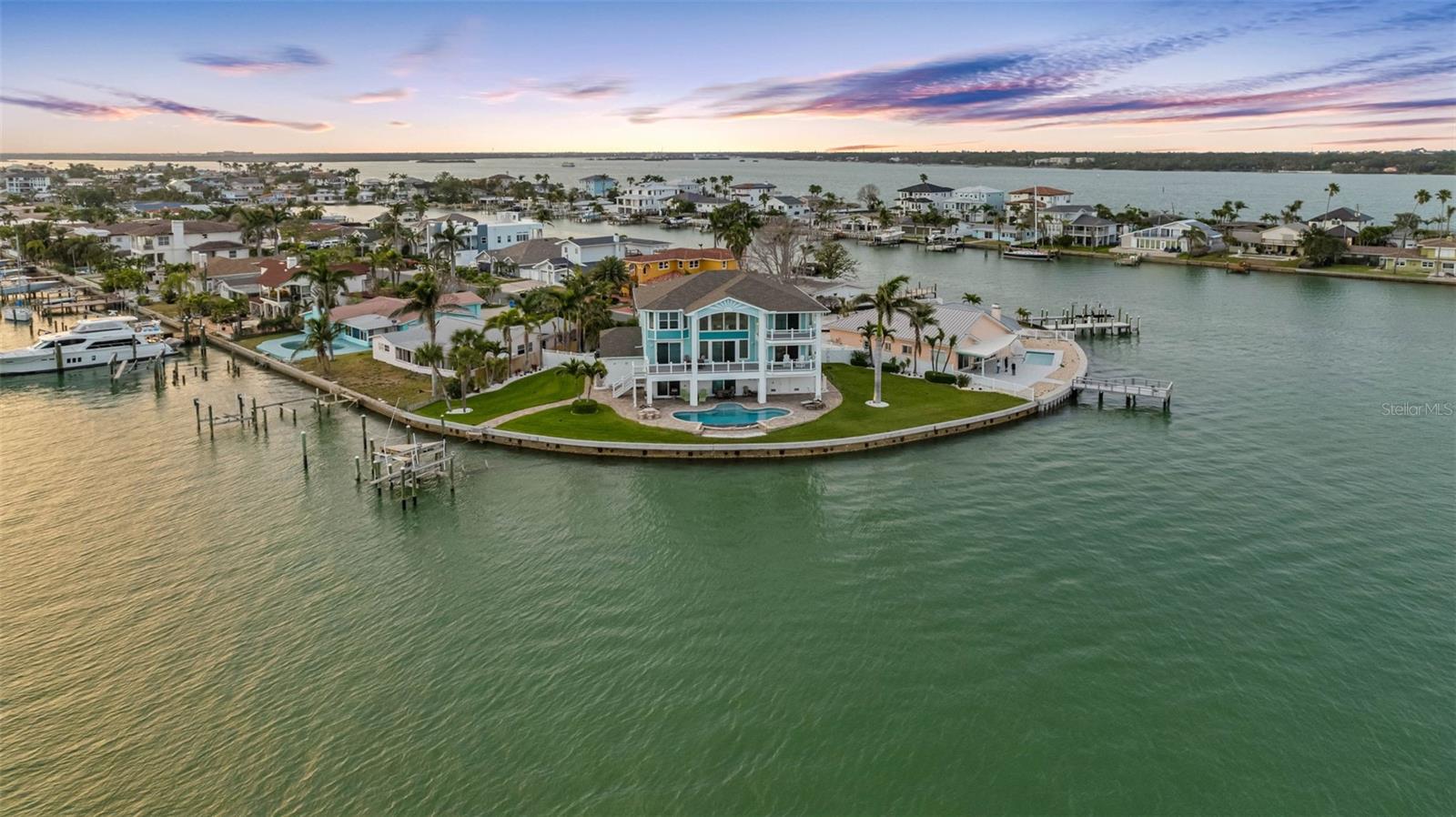 A Waterfront Sanctuary Where Key West Charm Meets Modern Strength! Nestled on a rare double lot on the exclusive Isle of Palms, this Key West-style haven offers a lifestyle few ever get to experience and even fewer are lucky enough to call home. Built in 2013 with enduring quality and architectural grace, this 4-bedroom plus office estate is more than just a residence; it's a front-row seat to some of the most breathtaking sunsets over Boca Ciega Bay you’ll ever witness. From the moment you step through the grand entrance, you’re greeted with soaring ceilings and a sweeping view of the glistening bay beyond. The openness, light, and sense of space immediately stir the soul delivering the kind of "WOW" moment that stays with you. The home is designed to frame the water, drawing your eye directly to the horizon where vibrant skies melt into tranquil waves. Situated on an expansive 214 feet of linear waterfront, the property wraps around the bay like a protective embrace offering privacy, presence, and panoramic beauty. The new composite dock and 10,000-lb boat lift are ready for your watercraft and sunset cruises, while the fabulous pool invites you to lounge in luxury or host unforgettable waterfront gatherings. Structurally, this home stands as a fortress disguised as paradise. Built using the HurriBolt system, it was engineered for strength and resilience, giving you peace of mind during Florida’s stormy seasons. With two brand-new HVAC compressors and generator-ready electric already in place, you can enjoy every comfort year-round with modern efficiency and reliability. Inside, the layout flows with ease and elegance ideal for both relaxed living and refined entertaining. The dedicated home office offers a private retreat for work or creativity, while each bedroom is a sanctuary in itself. Yet it’s the view, always the view that brings it all together, offering peace, inspiration, and the magic of waterfront living. Located just moments from the sugar sand beaches of Treasure Island, this is one of the only homes on Isle of Palms with such an impressive double-lot footprint. Whether you’re boating, swimming, working remotely, or simply watching the sun dip below the waterline with a glass of wine in hand, this home invites you to slow down, breathe deep, and savor life in one of Florida’s most cherished coastal communities. This isn’t just a home it’s your own private piece of paradise.