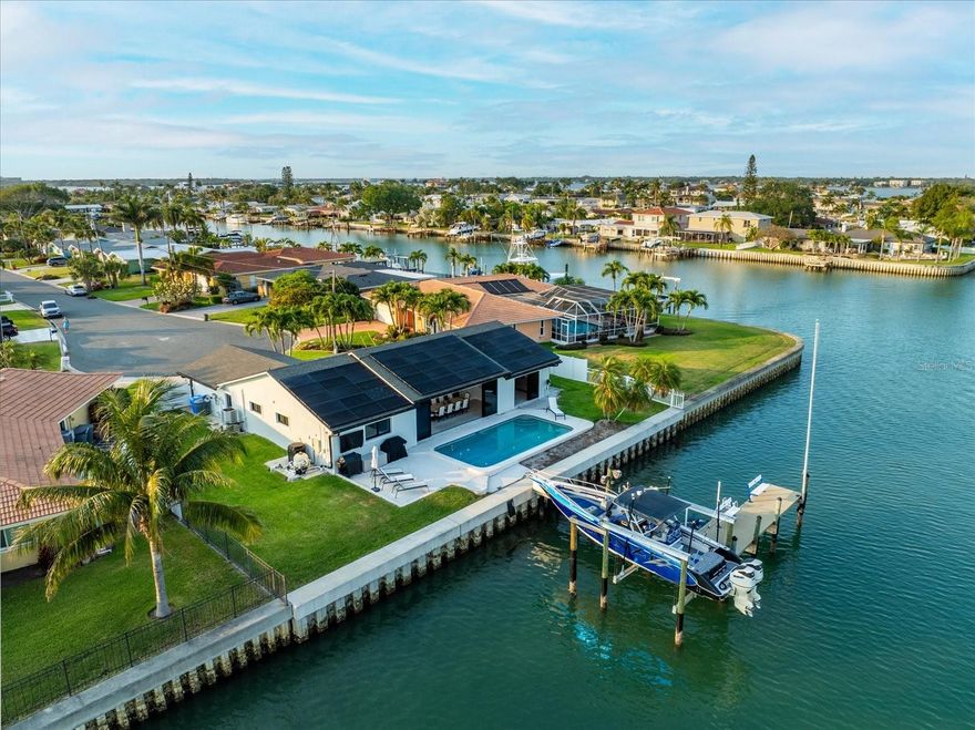 Waterfront Oasis on Treasure Island completely updated to perfection!! Enjoy the ultimate boater's paradise with this stunning canal-front home, mere steps away from Treasure Island beaches. Featuring a 13,000 lb boat lift, a brand new dock with composite decking and wrapped pilings, plus water and electric hookups. Indulge in luxury living with completely updated interiors boasting stainless steel appliances, granite countertops with a waterfall edge, Viking and Fisher & Paykel appliances, double ovens and double refrigerator. This is a chefs dream kitchen with an induction stove top and pot filler for your convenience. Every room offers picturesque water views, complementing the open floor plan and primary bedroom with a walk-in closet and smart Kohler Connect shower with no valves, all automated with app. Outdoors, delight in a fully automated saltwater pool, new separate hot tub and outdoor shower. No fixed bridges, direct intracoastal waterway access, and deep sailboat water make this a true gem. Plus, enjoy modern conveniences like hurricane impact windows and doors, 18,500 watt solar panels with 40,000 watt Sunfusion battery backup ($150,000 value), water softener system, New 23 sear Bosh HVAC system, all new electric and plumbing in 2021, surround sound throughout the house, and soundproof walls. Don't miss your chance to live the waterfront dream!