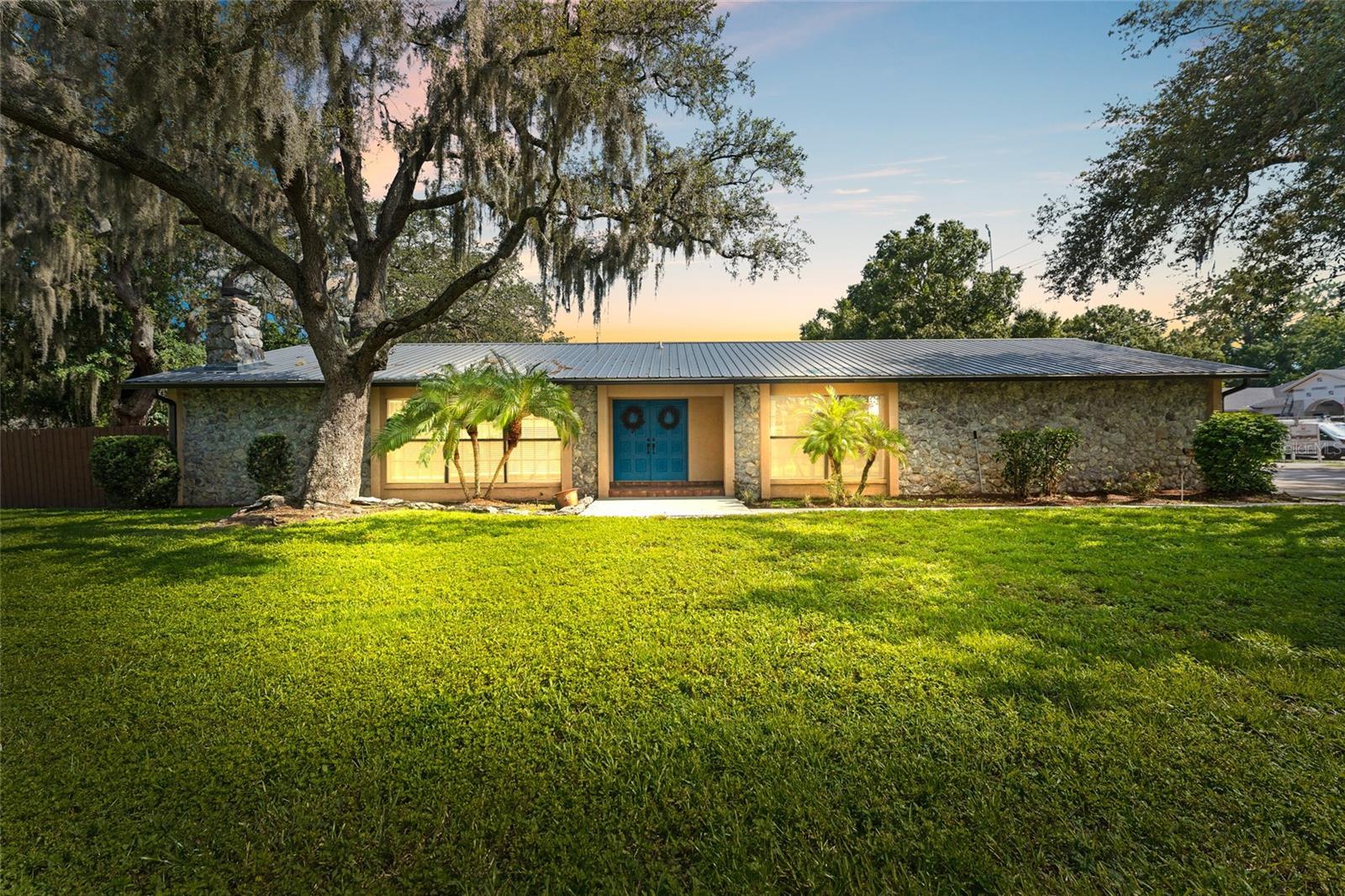 Situated on an OVERSIZED 0.32-acre lot in the heart of Carrollwood, this beautifully updated ranch-style POOL home is a must-see! Offering 3 bedrooms, 2 bathrooms, and 2,020 square feet of well-designed living space, the home is surrounded by mature oaks, tropical landscaping, and a colorful garden that enhance its private, inviting atmosphere. Inside, you’ll be greeted by a warm, open-concept layout anchored by a striking floor-to-ceiling stone fireplace and wide plank wood-look flooring. The fully renovated kitchen is a true centerpiece, featuring crisp white cabinetry, granite countertops, a massive center island, stainless steel appliances, and designer lighting. Both the primary and guest bathrooms have been beautifully updated with stylish finishes and modern fixtures, adding to the home’s move-in-ready appeal. Expansive sliding glass doors fill the living and dining areas with natural light and open to a resort-style backyard featuring a sparkling pool, multiple seating areas, and a covered outdoor kitchen with a granite-topped bar, built-in grill, and ceiling fans — your year-round backyard escape! A large storage shed adds convenience, and the fully fenced yard provides a quiet space to unwind. Additional features include an oversized driveway, 2-car garage, and a durable metal roof for long-term peace of mind. No HOA, no CDD fees, and no flood insurance required! Located in the heart of Carrollwood, and just minutes to Tampa International Airport, downtown Tampa, Raymond James Stadium, George M. Steinbrenner Field, dining, shopping, medical facilities, and the beaches—this home truly offers the best of Florida living. Schedule your private showing today!