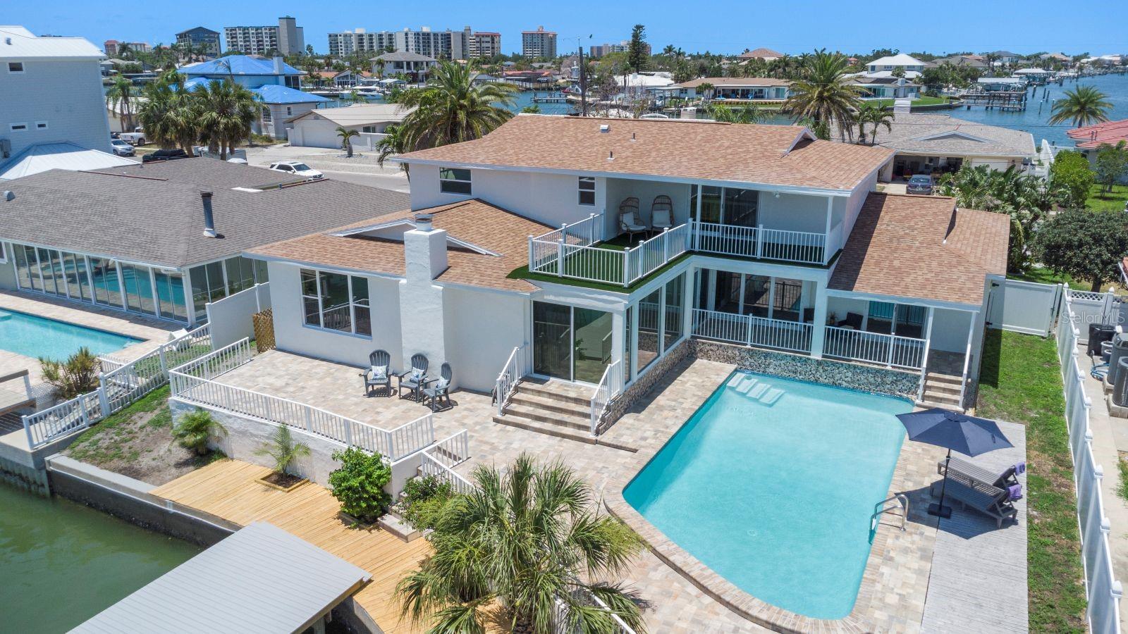 Elegant Waterfront Home on prestigious Island Estates offers Florida lifestyle at its best! The home sits at the end of beautiful Palm Island, safely elevated high above the water line. The 5-bedrooms 4-baths home is filled with sunlight and offers an open concept living with beautiful water views. Welcome your guests …to gather in the elegant 2-story open ceiling living room …. to sip a Prosecco on the upstairs balcony overlooking the water ….or to get cozy around the woodburning fireplace. Outside you are greeted by a lush green front yard, an elegant driveway, a sparkling saltwater pool, a large pool deck to watch the dolphins come by, and a brand-new dock and boat lift for your dreamboat. The waterfront has deep water access that welcomes every type of boat and sits right on the intracoastal waterways that take you out to Gulf. Whether you're looking for a full-time waterfront residence or a seasonal getaway, this easy to maintain property has it all. Upgrades include 2 new HVAC systems to cool down the summer heat, impact rated doors and windows for peace of mind during storm season, new impact rated garage door, new custom kitchen with granite countertop, new stainless-steel appliances, new bathrooms, new pool pump, newly renovated pool and much more. Irrigation is supported by reclaimed water with new pipes and sprinkler heads. Clearwater Beach is an all-year-round Gulf coast paradise with beautiful white sandy beaches, clear turquoise water and a family friendly atmosphere. Luxurious hotels, trendy restaurants, bars with live music and the famous Pier 60 with its nightly vendors and performers, will keep you entertained! Call us today for your private showing!