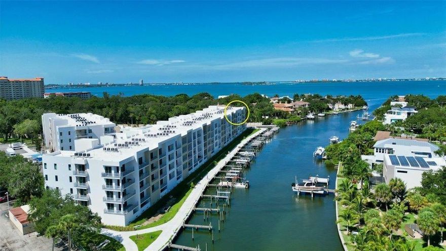 Experience this coveted top floor and closest to the Bay location and the fantastic water views, beautiful sunsets, five-star amenities, gated access, and incredible proximity to Downtown Sarasota, the Bay Park, and the area's spectacular beaches.  PLUS option to purchase a boat slip with 16,000 lb. lift and 2nd parking space with sunshade! Built in 2022, this residence affords a second-to-none waterfront lifestyle. The 1 bedroom + office/den, 2 full bath unit features upgraded finishes, sizable living area, designated dining space, serene primary bedroom with luxe owner's bath, expansive custom closet, and private open-air terrace overlooking the water. Perfect as a primary or secondary home, or investment property where weekly rentals are welcome. Entertain in your chef's kitchen with stainless Samsung appliances, upgraded white subway tile backsplash, soft close cabinetry, statement quartz countertops and a generously sized peninsula. The main living space fills with natural light and affords stunning water views through 9' hurricane-rated sliding glass doors. The office/den is perfect for all of your organizational needs. Additional noteworthy features include custom designed closets, in-unit laundry with Samsung washer and dryer, pendant lighting, designer ceiling fans and custom window treatments. This unit includes 1 under building parking space and private secure storage. The Strand, brought to life by renowned architectural firm HOYT, and award-winning interior design firm JKL Design features fantastic resort style amenities including heated swimming pool/spa, fitness center, gas fire pit and grills, electric car charging stations, dog park, 1000' boardwalk, kayak and paddleboard launch, and ample guest parking. In addition to the fabulous surroundings and culture of Downtown Sarasota, you can enjoy the restaurants, cafes and bars that are just a stone’s throw away from The Strand. Make the most of the azure water and explore the top-rated beaches and bays and make this exceptional residence, community and city your home today.