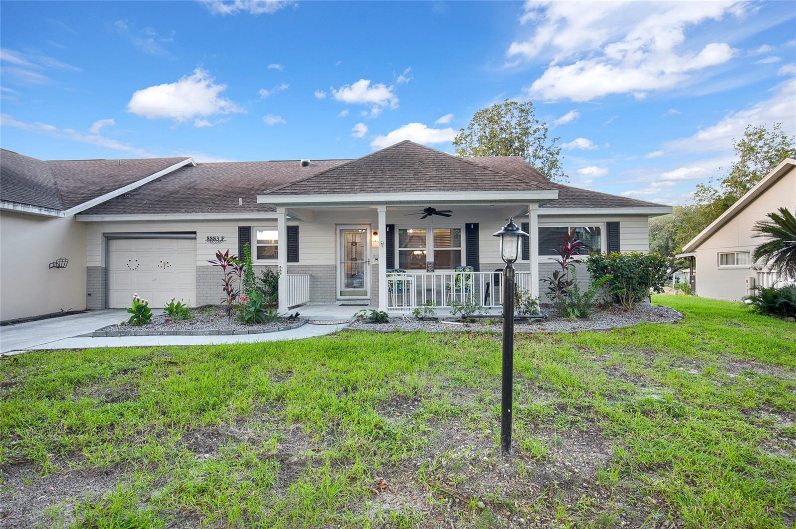 Come and visit this END UNIT villa at On Top of the World in Ocala's premiere 55+ Gated community. A spacious front porch perfect for enjoying your morning coffee or evening beverages welcomes you to this home. Step inside into the living room/dining room area and notice the laminate flooring throughout. The bedrooms are on the left side of the home with the guest/hall bath with tub and tile surround in between. The primary bedroom is in the back for privacy with an ensuite bath along with a step-in shower and large walk-in closet. The kitchen has been nicely updated with newer appliances and Granite countertops! The Florida Room is fully finished with heat/AC. The lanai has been converted into an all season room. Washer/Dryer are in the garage. The monthly HOA fee includes basic Spectrum cable, irrigation water, roof maintenance & repair, exterior painting every seven years, exterior maintenance and insurance, landscaping, trash & recycling, 24/7 guarded gates and all the amenities that OTOW provides, three pools (2 outside & 1 inside & another under construction), two state of the art fitness centers, pickleball, billiards, archery range, corn hole, bocce ball, tennis, shuffleboard, horse shoes, remote control flying field and race cars, 175+ clubs, woodworking shop (extra fee), library, and much, much more! A golf cart community with access to three shopping centers.