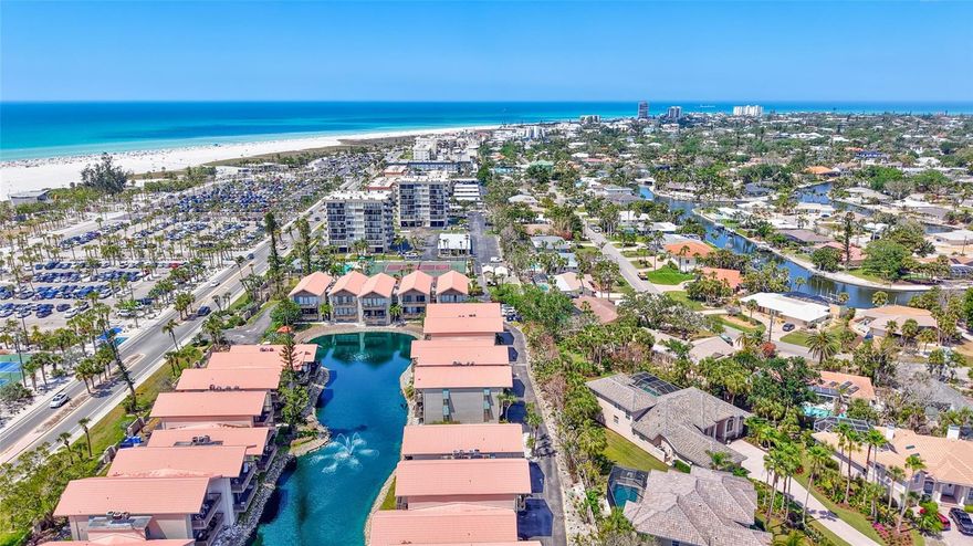 Rarely available, this recently fully-renovated lake-front townhome is steps away from the crystal sands of Siesta Key Beach!  Beautifully updated with a Coastal Chic interior, this end unit townhouse lives large.  Light & bright with high ceilings, an open floor plan & four sets of glass sliders inviting the Gulf breezes inside makes each new day a delight. This 2-bedroom, 2-full bathroom home has a 1-car enlarged garage with ample storage for the water & sunshine toys, a covered balcony for coffee at sunrise & a 21’ long covered porch to celebrate evening sunsets!  The kitchen with soft-close, hard-wood cupboards, granite counters & bar top is well equipped for efficiency to serve the adjacent dining table, bar seating or rattan cozy coffee table for two!  The Primary Ensuite has a lake-view from the King bed, walk-in shower, dual vanities and 3 separate closets. Bedroom 2 is separated on the 2nd floor and enjoys the morning sunrise & adjacent 2nd full bath. The solid-surface floors & the full-sized inhouse washer & dryer provide easy maintenance & electric power shades on all windows provide closure at the end of the day.  This unit was totally remodeled with high-end furnishings & interior finishes several years ago & has been lightly used, reserved for only Family & Friends. Onsite amenities include tennis, a resort-style pool, BBQ & picnic area. Across the street, the Siesta Key Public Beach offers Pickleball, Tennis, a Kid’s Playground, Lifeguards, wheelchair access & Sand Volleyball on the beach! A FREE Trolly runs up & down the Key to a plethora of restaurants, bars, small boutiques & shops. Being sold turn-key, this is a great opportunity for a new owner and/or is also a great investment property.  There is an on-site, short-term Rental Company with a waiting list for 2026 reservations. Siesta Key Beach was Ranked in 2025 by Tripadvisor #1 in the U.S. & #4 in the World. Don’t miss this opportunity for a fabulous townhome across the street at Our House at The Beach!