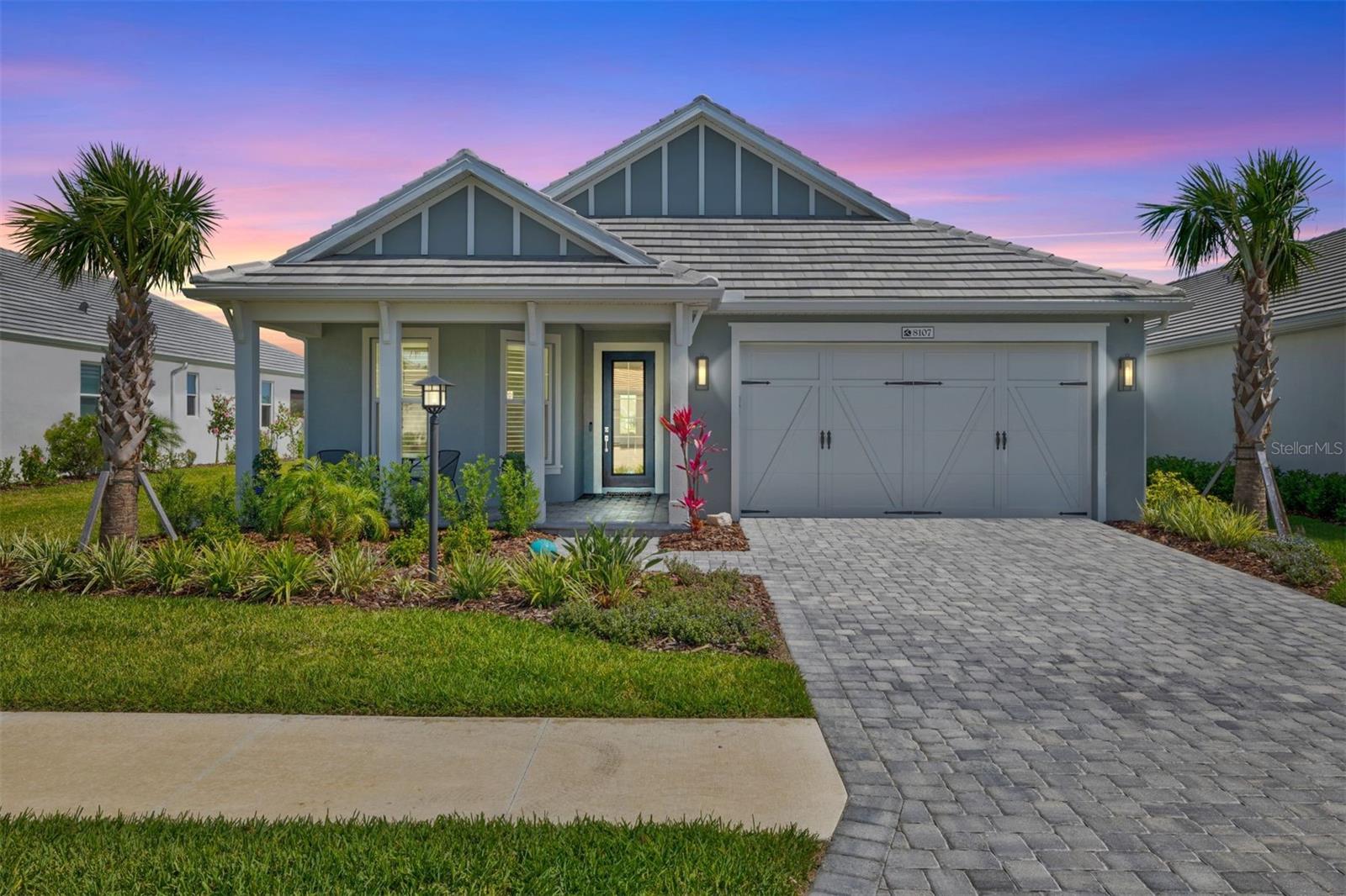 Experience the highly sought-after Lakehouse Cove at Waterside, part of the prestigious Lakewood Ranch community. This nearly-new Cay model offers style and sophistication with two bedrooms, a spacious flex room, 3-car tandem garage and gorgeous, south-facing waterfront views. Inside, the home is adorned with upscale finishes designed for both style and functionality. Porcelain tile flooring runs throughout, combining durability with easy maintenance, while tray and vaulted ceilings enhance the sense of openness and sophistication. Designer light fixtures and fans, 8-foot six-panel doors, and upgraded wood trim and plantation shutters elevate the overall aesthetic. Hurricane impact glass and a whole house generator provide peace of mind and safety during inclement weather. The gourmet kitchen serves as the heart of the home, featuring sleek European cabinetry that blends contemporary design with practicality. Outfitted with top-tier appliances, abundant lower drawers for storage, a luxurious marble herringbone backsplash, and quartz countertops, this kitchen is a chef’s dream—perfect for cooking and entertaining alike. The open-concept living room boasts vaulted ceilings and a stunning wall of sliders that connect indoor and outdoor spaces. The lanai screen has been upgraded to clear-view for uninterrupted views of the water. The primary suite features a spa-inspired en-suite bathroom offers indulgent features like a double-sink vanity for convenience, a seamless glass walk-in shower with sleek design elements, and a spacious walk-in closet with thoughtfully designed closet system. On the opposite side of the home, the second bedroom with custom closet system and a guest bathroom provide a private retreat for guests or family members, ensuring comfort and privacy. The versatile flex space offers endless possibilities—it can serve as a cozy home office, an inviting reading nook, or even an additional guest room. The laundry room is thoughtfully designed for stylish storage, with abundant, quality cabinetry and quartz countertops. A strategically placed half bathroom adds practicality to the layout. The three-car tandem garage is equipped with custom storage cabinets, a utility sink, and features upgraded showroom-quality epoxy flooring. Lakehouse Cove offers an unparalleled lifestyle with resort-style amenities that make every day feel like a vacation. Residents enjoy access to a luxurious pool, a state-of-the-art fitness center, pickleball courts, dog park, tennis courts, firepit, clubhouse, and a private marina equipped with kayak and canoe launches. A water taxi provides convenient transportation to Waterside Place on Sundays—giving residents easy access to upscale dining, shopping, and entertainment options.