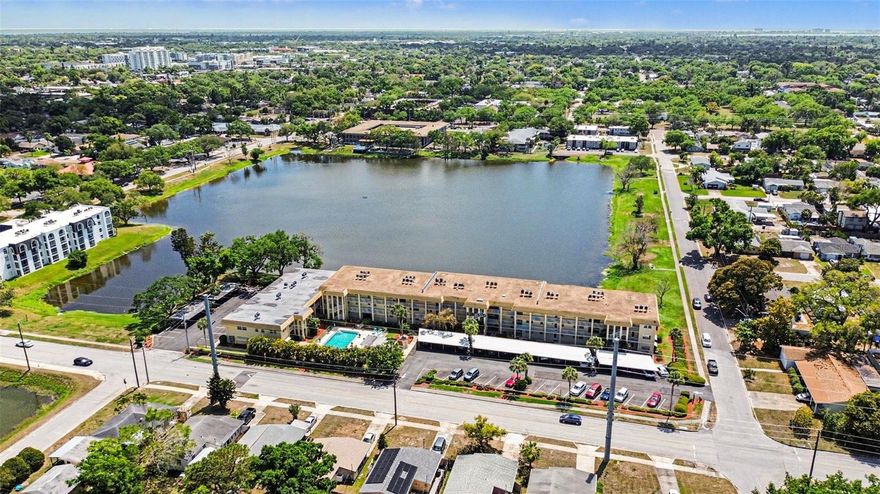 One or more photo(s) has been virtually staged. This spacious first-floor condo offers an ideal blend of convenience, comfort, and peaceful waterfront living. The community pool sits directly in front of your front door—perfect for relaxing or keeping an eye on little ones—while the back door opens to a beautiful lake view that brings a sense of calm to everyday life.

Inside, the long, open layout creates a natural flow from the kitchen into a combined dining and living area, offering plenty of room to arrange your space just the way you like it. Ceramic tile flooring runs throughout the home for easy maintenance and a clean, cohesive look.

The primary suite overlooks the lake and features its own private bathroom with a walk-in shower (no tub), a walk-in closet, and a red heat lamp for added comfort. The secondary bedroom sits on the pool side of the building and includes a built-in closet and great natural light. All appliances—including the washer and dryer—are included, making this home truly move-in ready.

Residents enjoy a friendly, welcoming community atmosphere. One neighbor described it as “a fantastic place to live,” with quick access to Tyrone Mall, restaurants, and everyday conveniences, plus an easy drive to downtown St. Petersburg and the beaches. Whether you're looking for a primary residence, seasonal retreat, or investment opportunity, this condo delivers exceptional value in a central St. Pete location.
