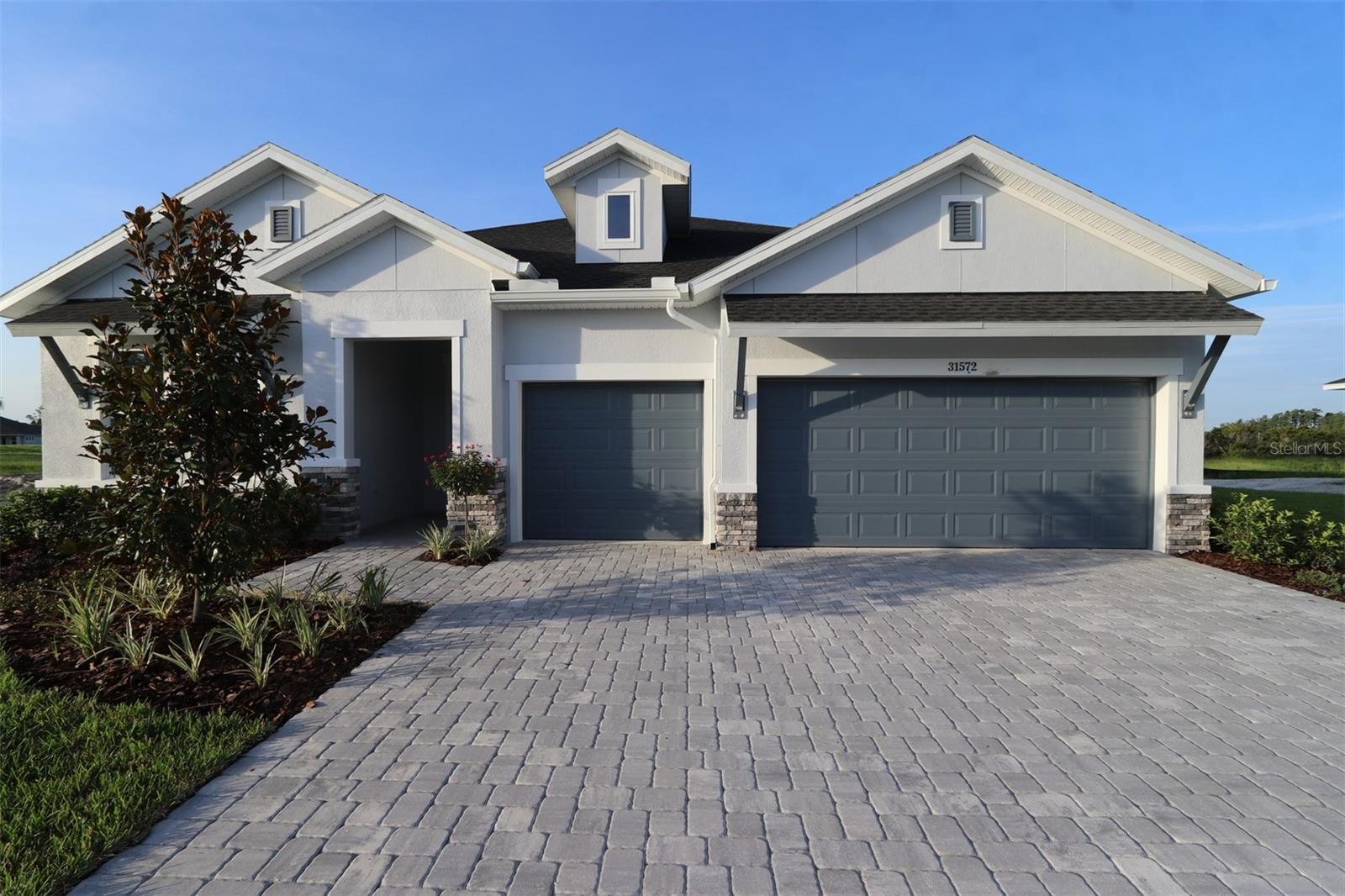 Welcome home to The Borrelli by David Weekley Homes, a beautifully designed floor plan nestled in the vibrant Chapel Crossings community in Wesley Chapel, FL. Set on one the largest homesites in Chapel Crossings with tranquil conservation views, this home offers both space and style for modern living. At the heart of the home, the open-concept kitchen connects seamlessly to the bright dining and family rooms, creating an ideal space for everyday living and entertaining. Sliding doors lead to a spacious extended lanai, perfect for enjoying peaceful outdoor moments. A comfortable guest suite with a private bath is conveniently located just off the kitchen—ideal for overnight guests or flexible living arrangements. Two additional bedrooms and a study space are ideally situated in the home. This home also comes with the peace of mind that comes with David Weekley’s industry-leading warranty, ensuring the highest standards of craftsmanship and customer satisfaction. Chapel Crossings offers an incredible array of amenities, including a clubhouse, resort-style pool, lazy river, pickleball courts, dog parks, playgrounds, and walking and biking trails — all within walking distance from your front door. Experience the best in design, choice, and service in Wesley Chapel, FL