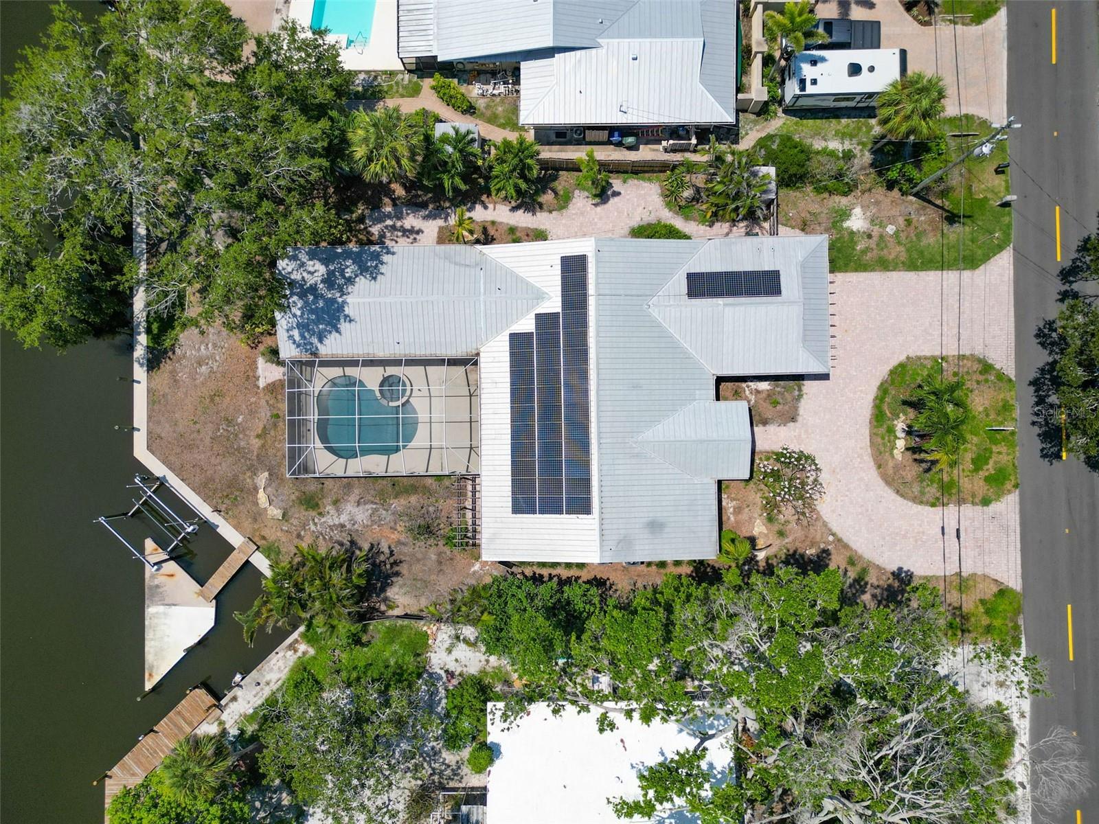 Now the lowest priced single-family home in Sara Sands, this is your opportunity to take this blank canvas and create your masterpiece. With canal frontage, a boat dock with a lift, heated pool & spa, a two-car garage, and solar panels this home offers a third of an acre at a prime location on Siesta Key. This home sustained storm damage during Hurricane Helene in September 2024 and has had appropriate mitigation completed. With a Spanish colonial inspired elevation, this home did not sustain damage to its curb appeal. On your approach, a circular paver driveway and charming front porch framed by natural wood elements and landscaping beds once plentiful with lush vegetation create stunning curb appeal. Step inside to a sprawling living space with a seamless flow from dining space through to the gorgeous kitchen. A beautiful fireplace once flanked by substantial built ins lends a warmth to the space while multiple sets of classic French doors allow for bright, Florida sunshine to flood the room. With a little help, the kitchen will be a chef’s dream again as the current layout features dual tone cabinets, attractive countertops and a show stopping island with seating for 5-6. With a wall of pantry cabinets, coffee bar and additional cocktail bar, there is no shortage of storage or possibilities! Each bedroom is exceptionally generous, but the primary suite is simply divine with a large footprint, dual walk-in closets and an ensuite bath will exude luxury in size and your chosen finishes. Step outside to your outdoor oasis featuring a paver pathway that connects multiple patios but ultimately leads you back to the stunning views of the canal. A golf cart ride, bike ride or leisurely walk will have you exploring the heart of Siesta Key’s village with eateries, shops, dessert shops and of course access to the beach with views of the sparkling waters of the Gulf. With some creativity and a bit of effort, this home be better than ever as your beautiful homestead for year round residency or seasonal Siesta Key dwelling!